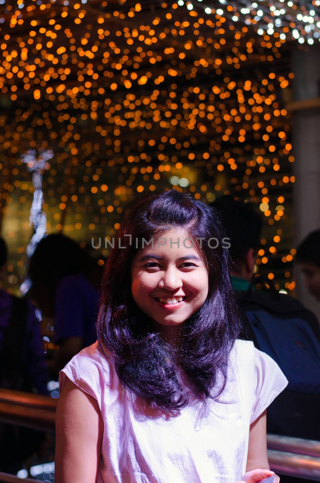 Portrait of young woman on bright lights background