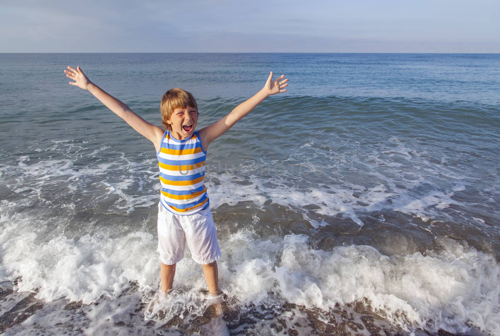 boy running through the water at the beach