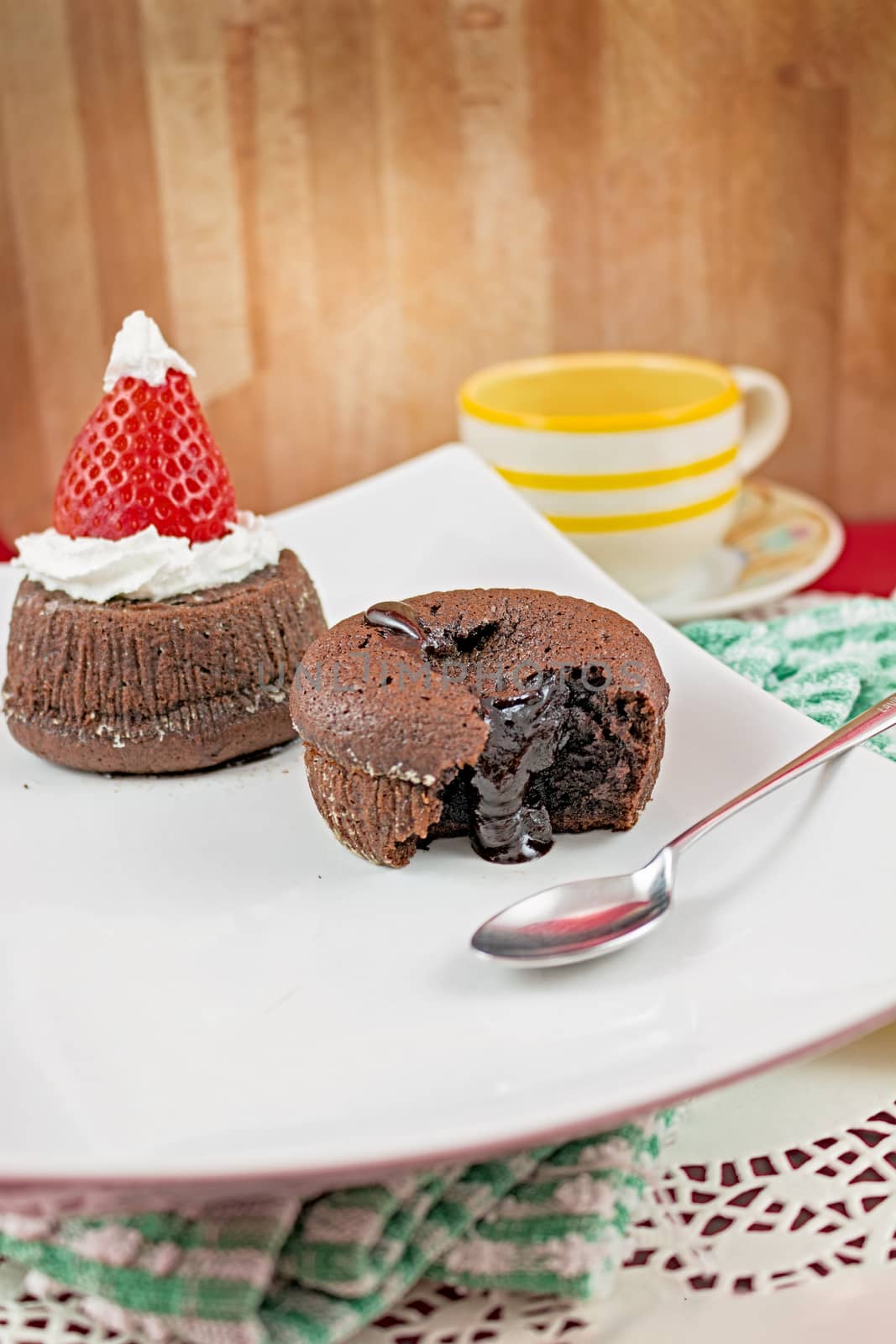 Plate with small chocolate cakes and teaspoon