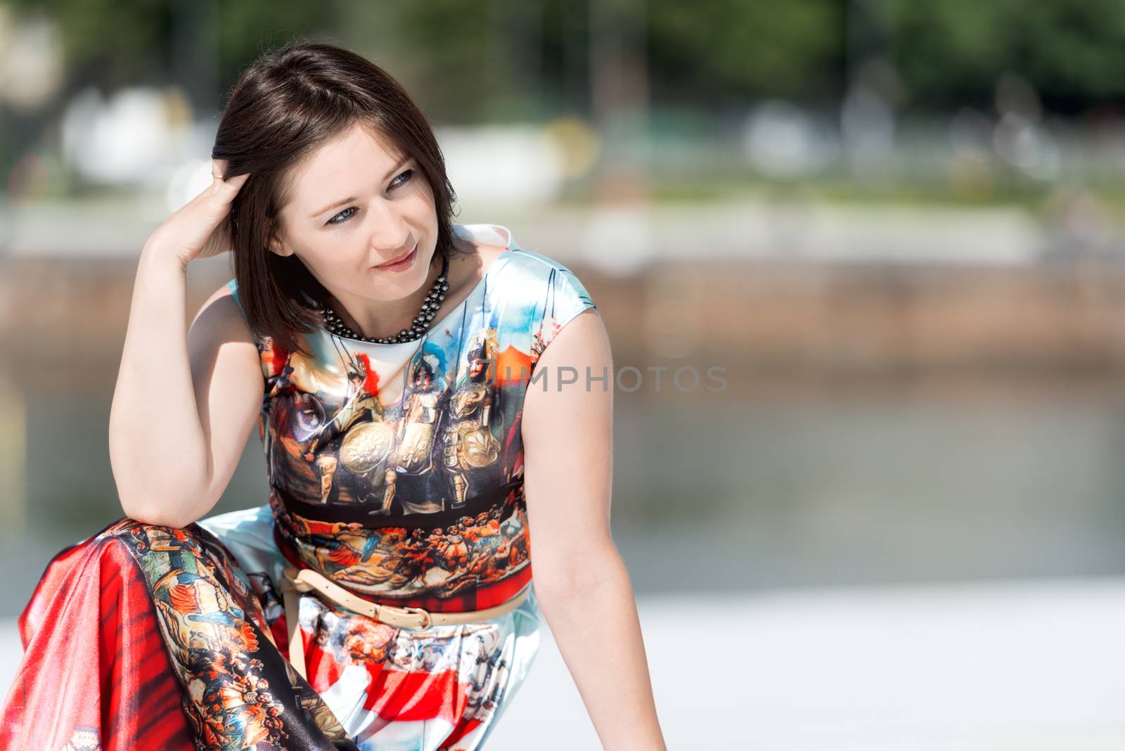 Brunette girl model in dress posing on exterior set