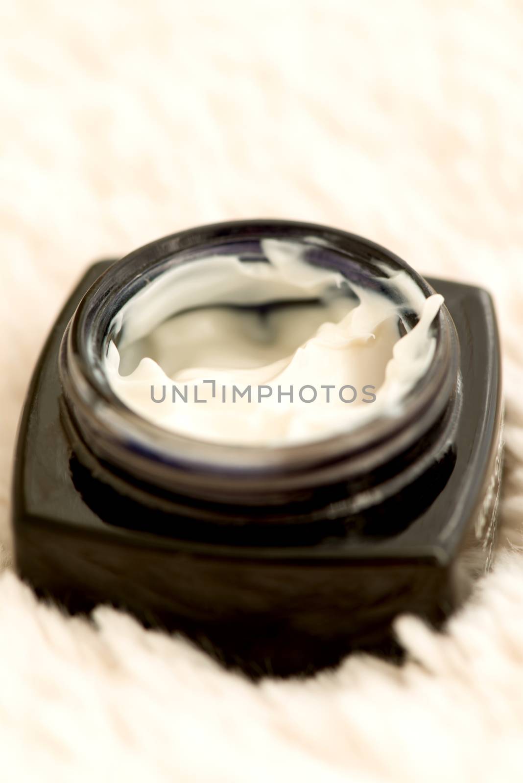 Cosmetic cream in an open jar with shallow depth of field