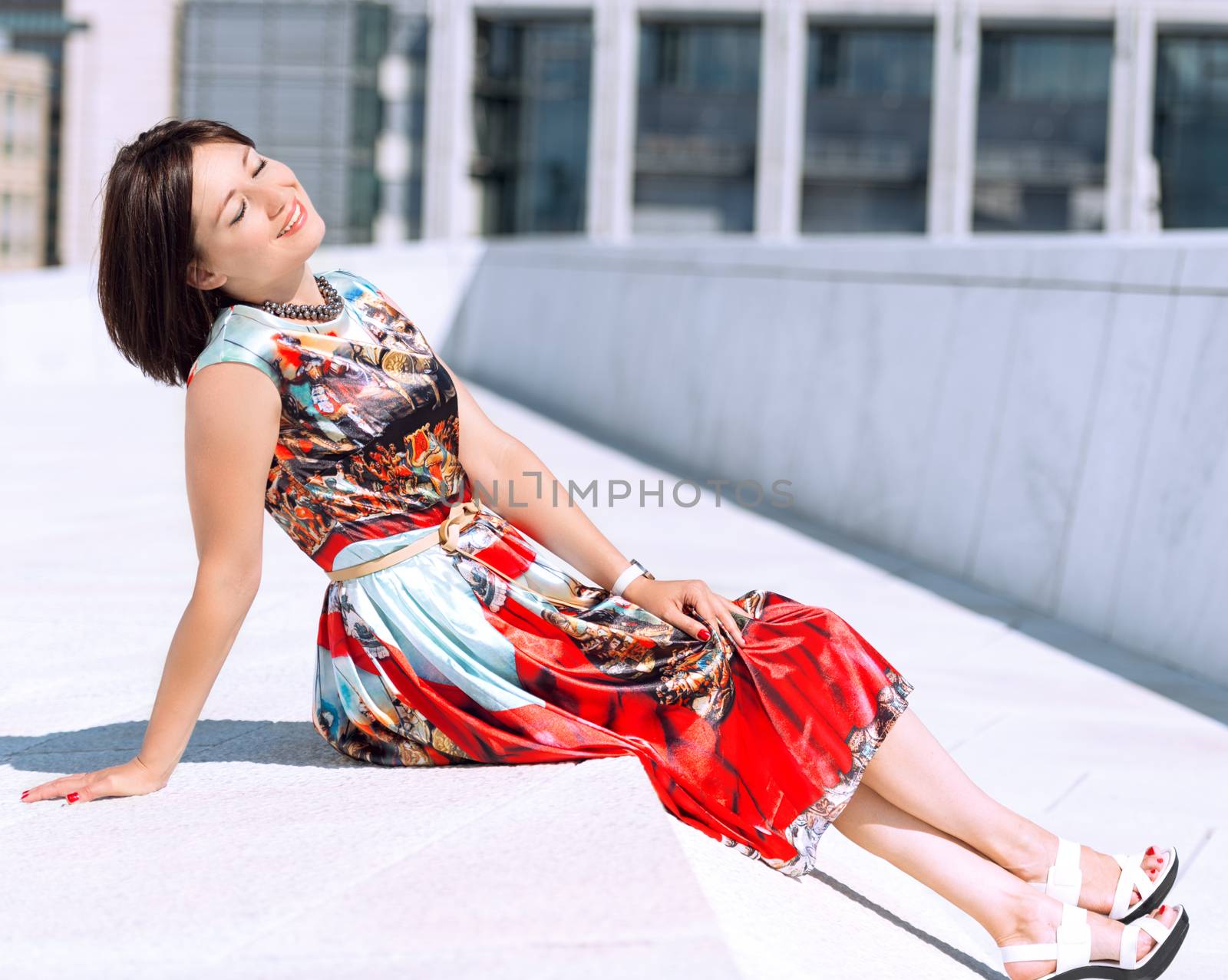 Brunette girl model in dress posing on exterior set