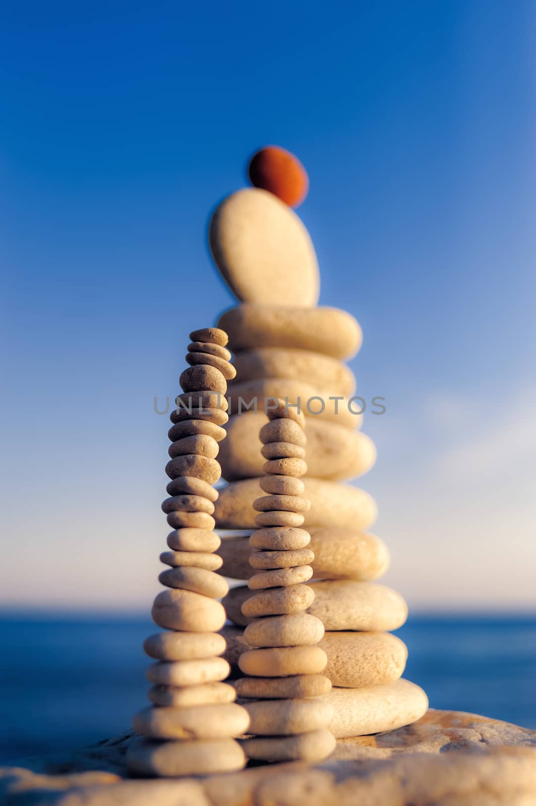 Balance of red stone on the top of stack of white pebbles