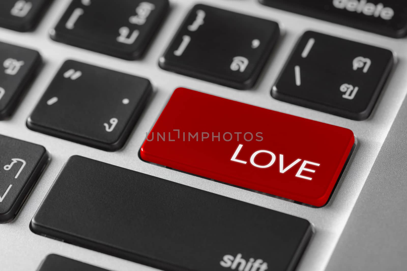 computer notebook keyboard selected focus on  red enter button with word Love