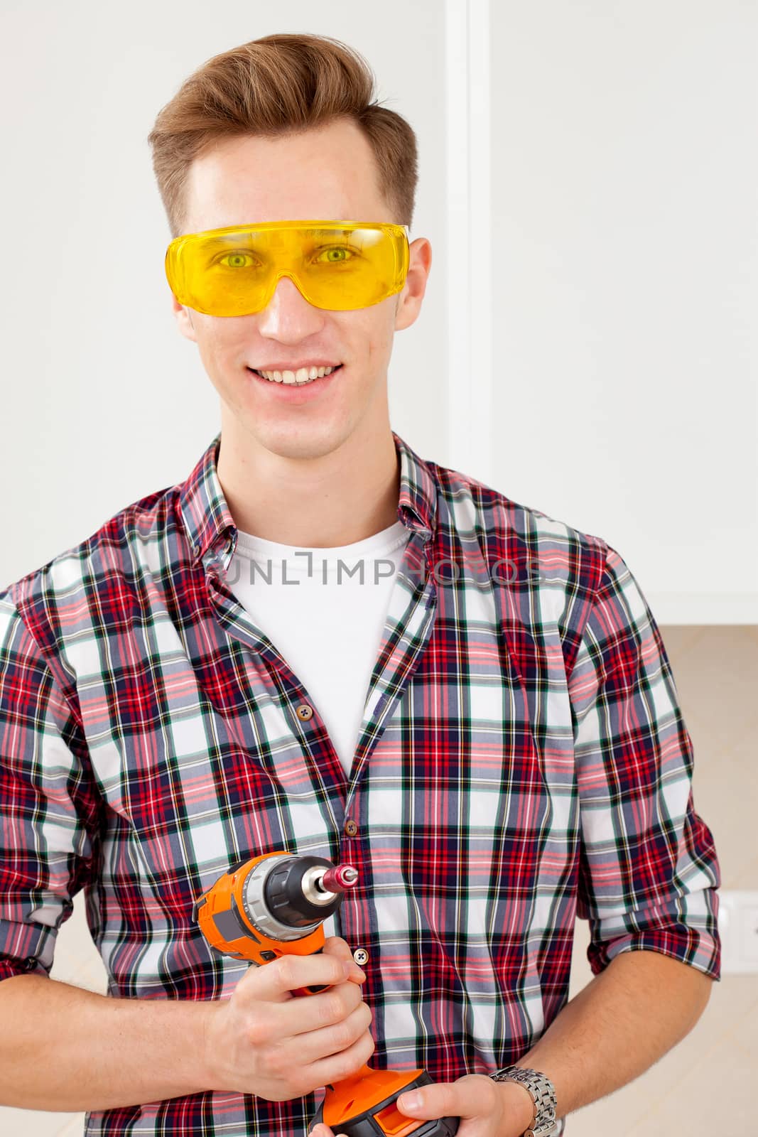 repairman in eyeglasses and with a drill in his hands