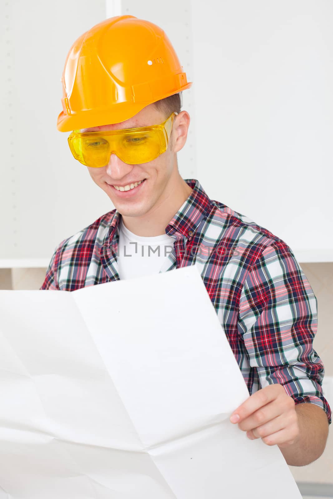 smiling architect  with repair plan in the interior new apartment