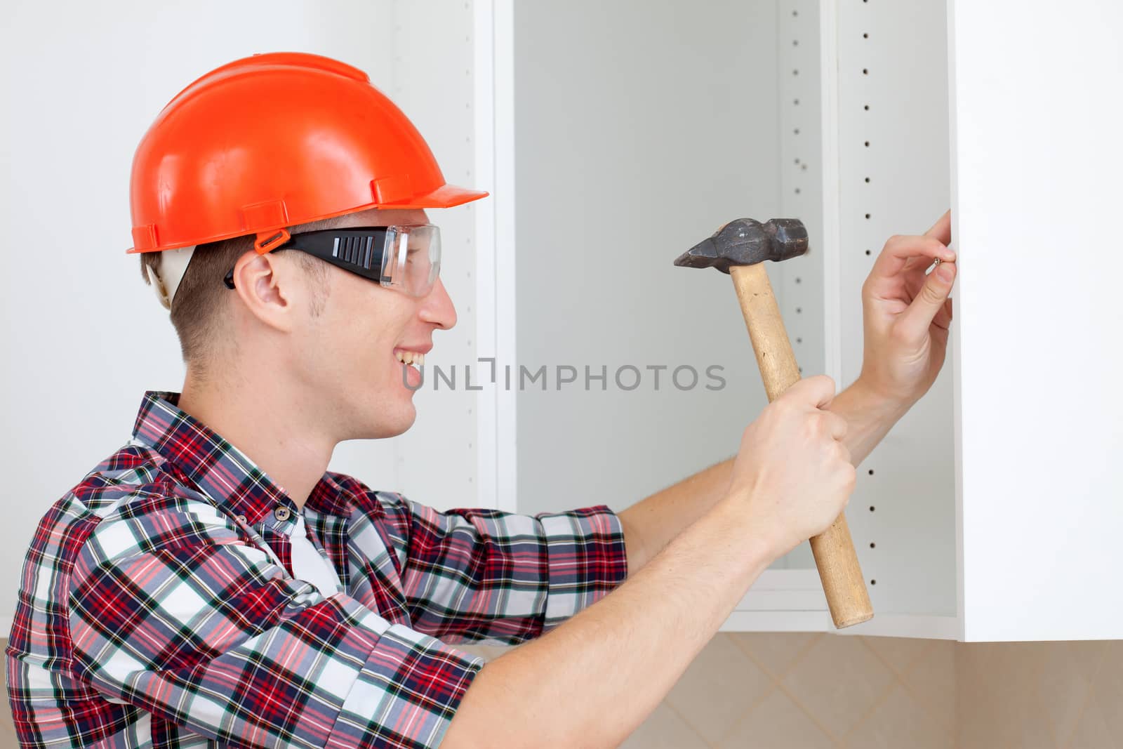 worker in protective helmet with a hammer