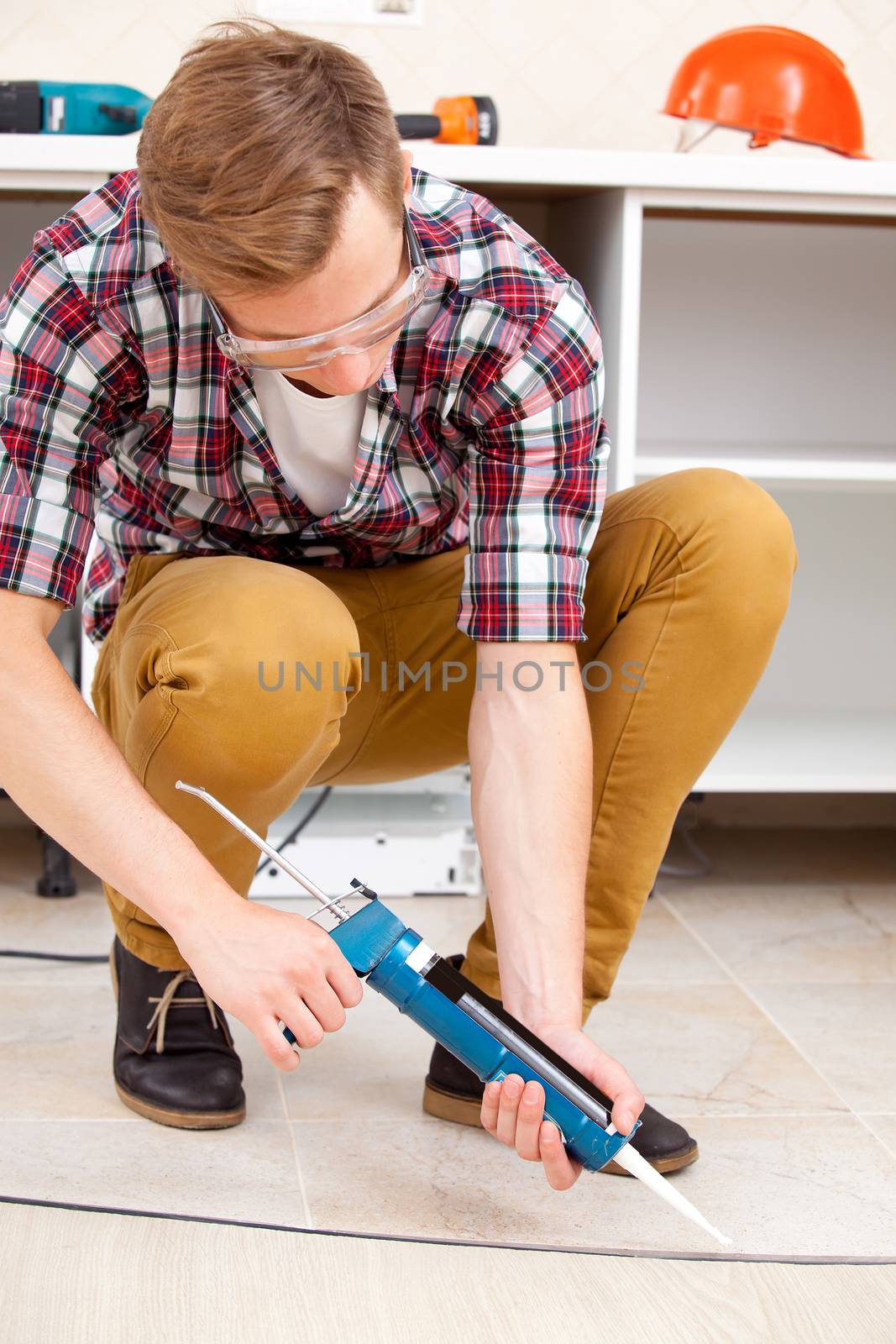 young worker repairing the floor