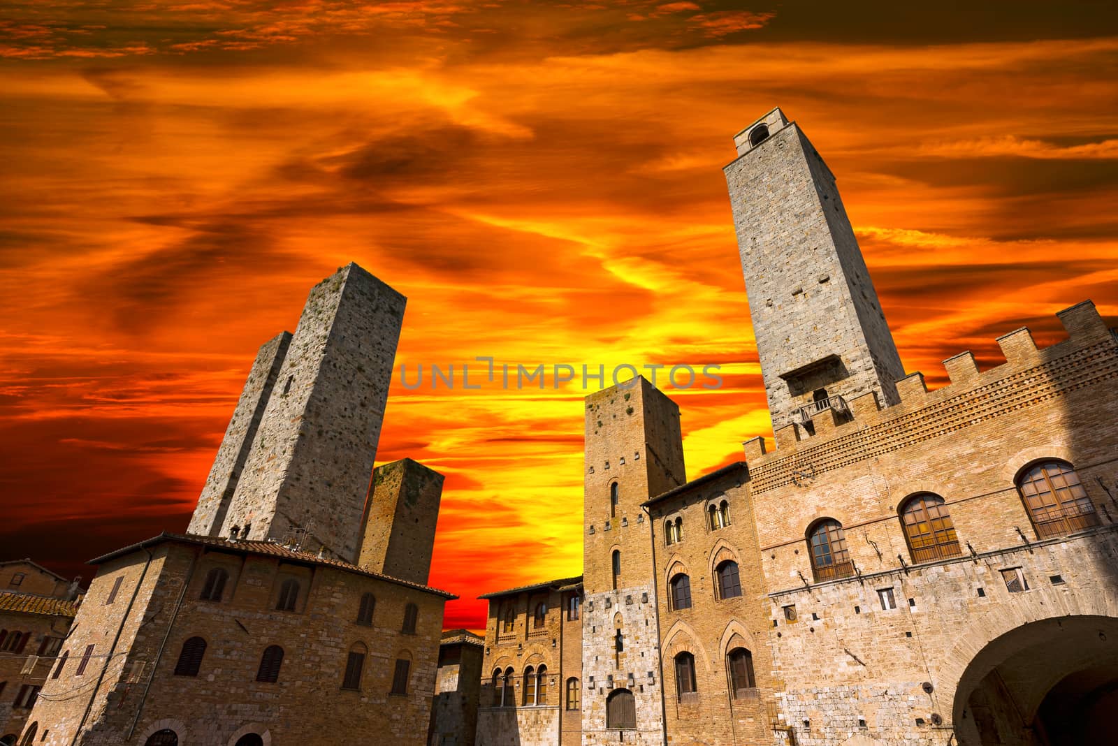Buildings and towers in Piazza del Duomo at sunset, San Gimignano medieval town (UNESCO heritage), Siena, Tuscany, Italy