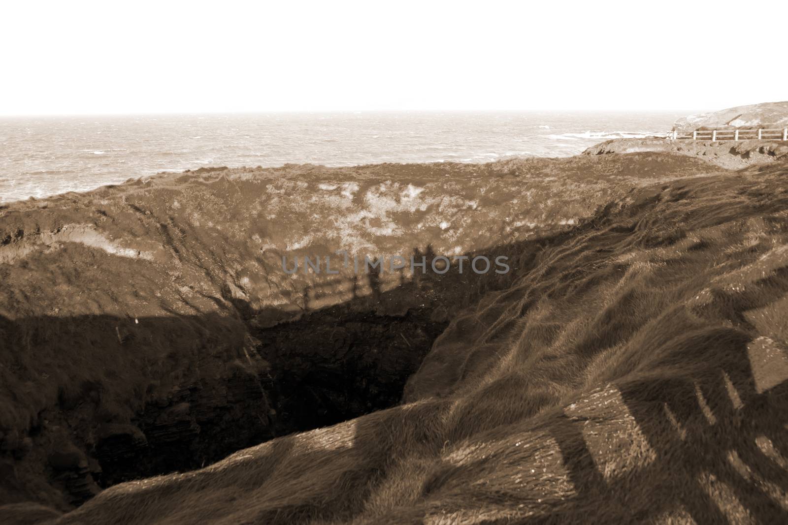 shadows of tourists looking into the nine daughters hole in Ballybunion county Kerry Ireland