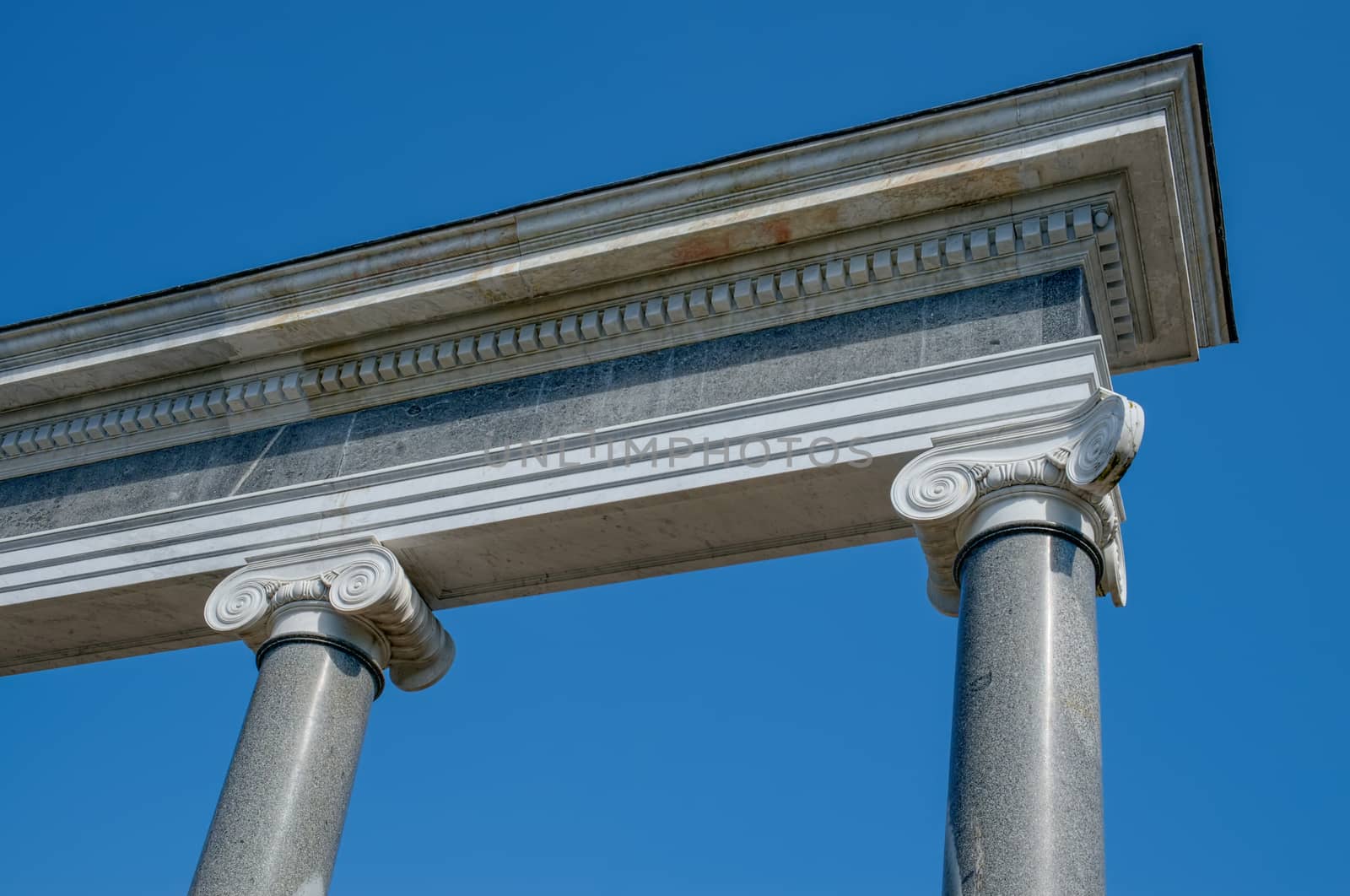 Ornately decorated Ionic  columns. Blue sky.