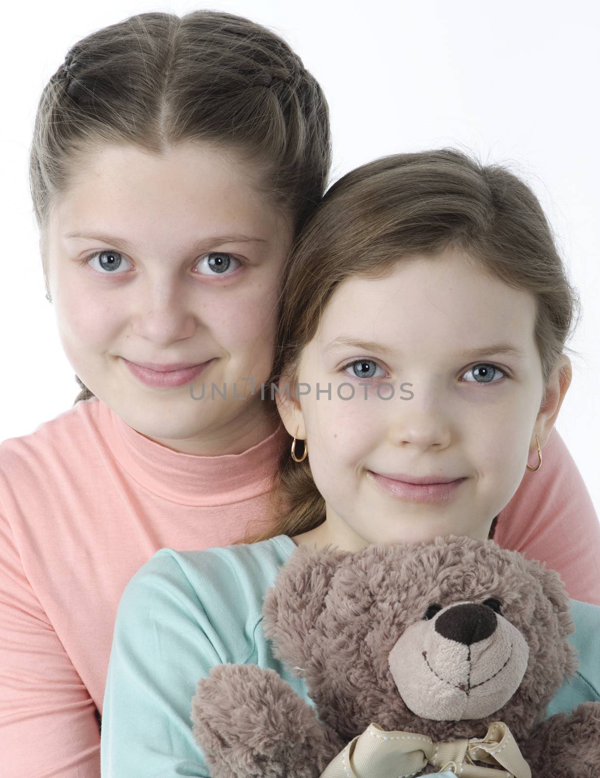 Portrait of pretty little girls holding teddy bear on white by velkol