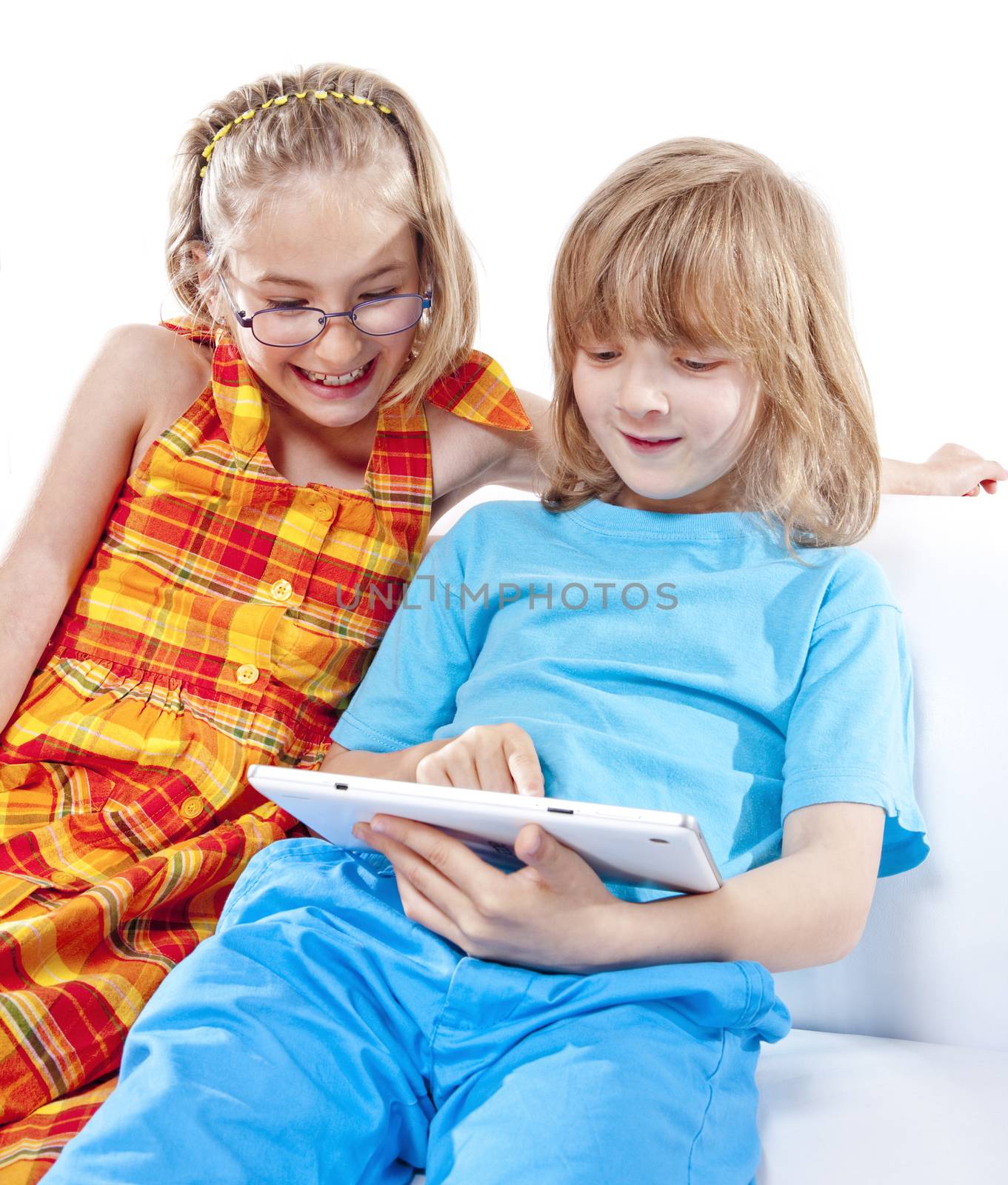 Two Children Having Fun with Digital Tablet by courtyardpix