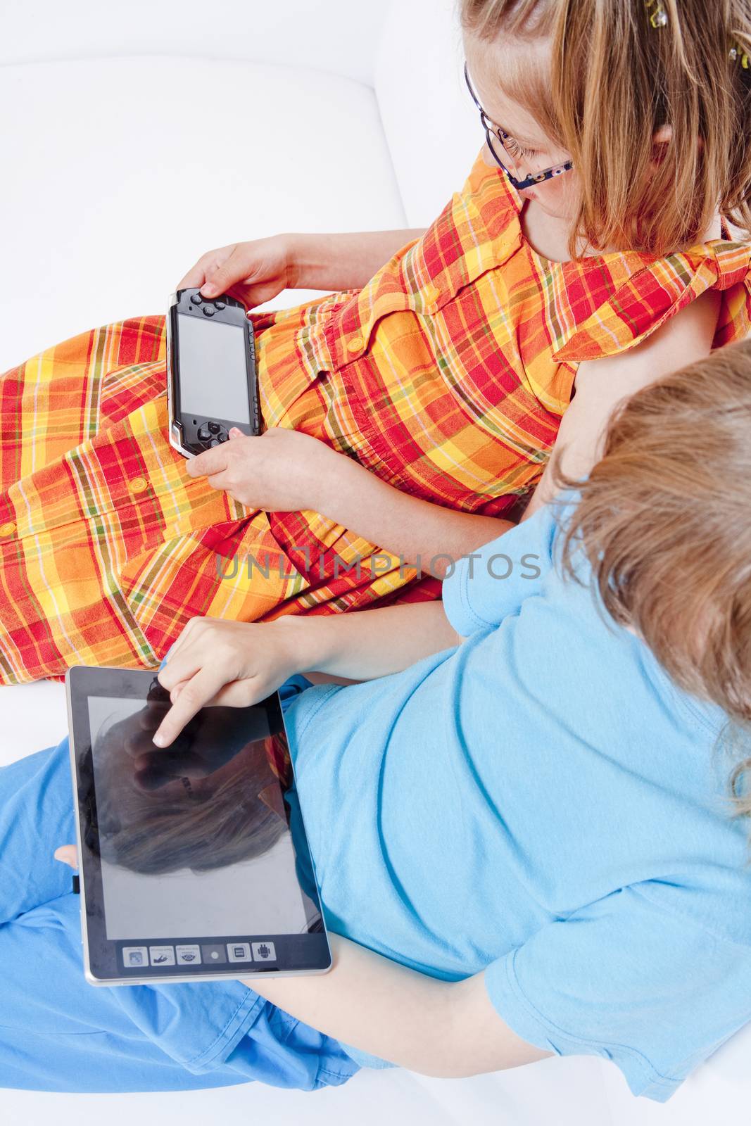 Two Children Having Fun with Digital Gadgets by courtyardpix