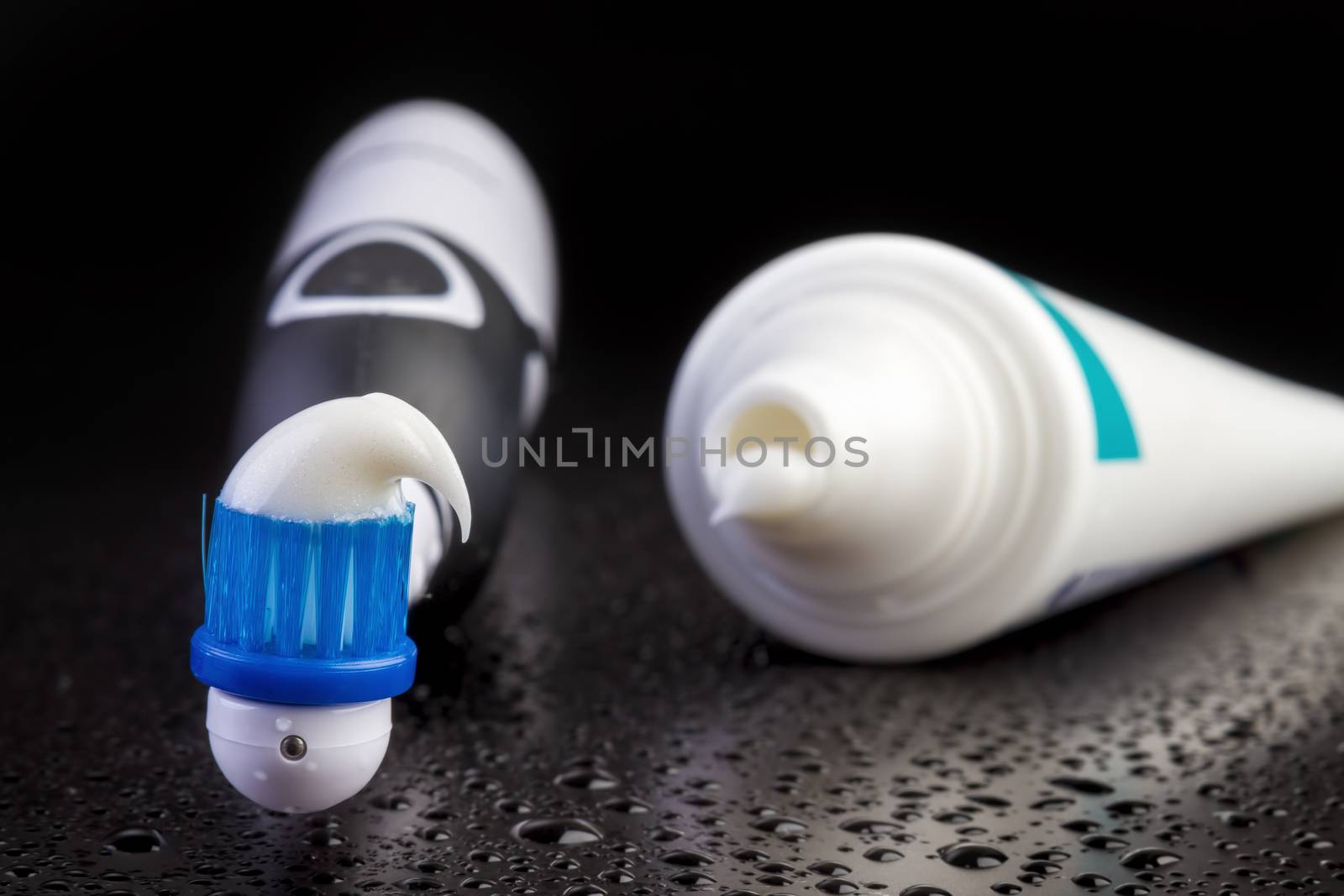 Blue toothbrush with toothpaste on black background