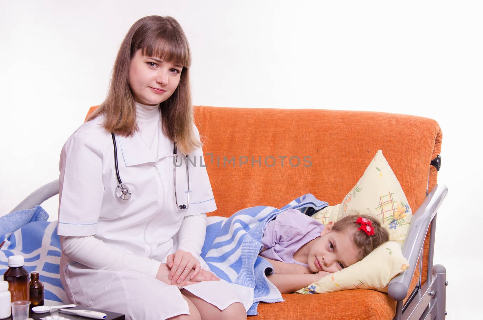 Doctor pediatrician examines a sick child at home