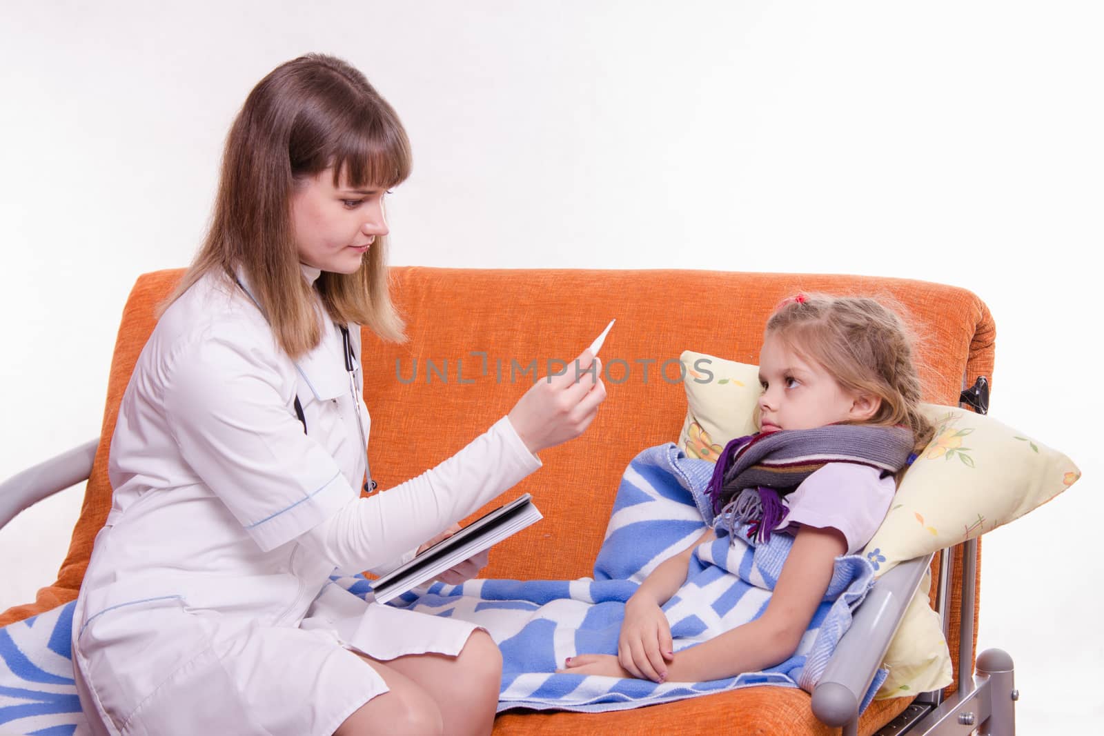Doctor pediatrician examines a sick child at home