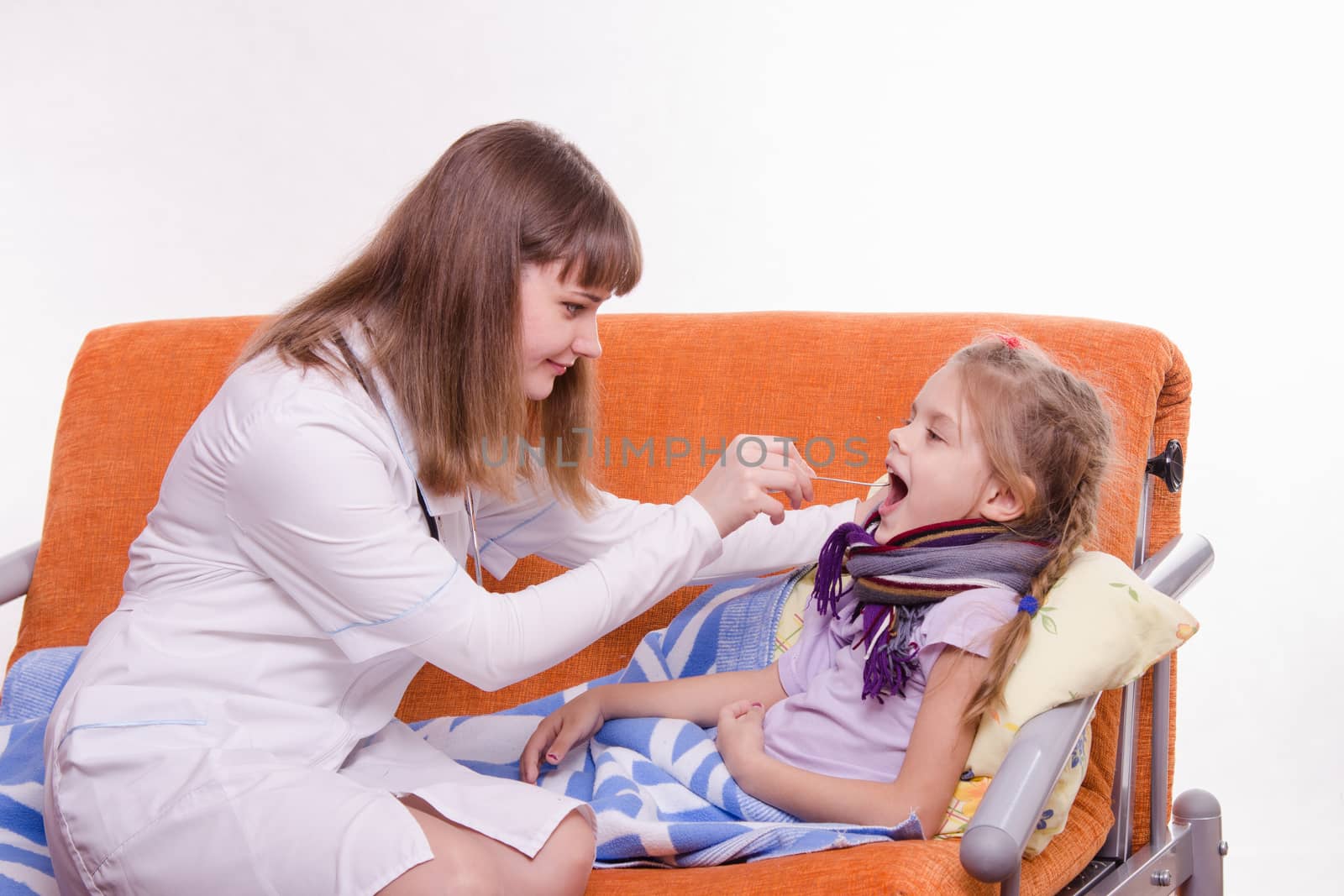 Doctor pediatrician examines a sick child at home