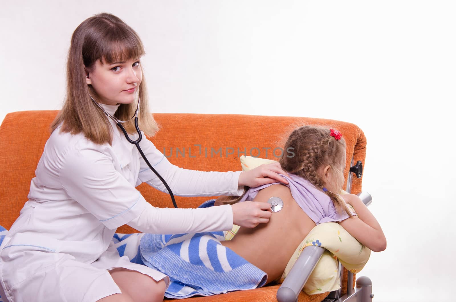 Doctor pediatrician examines a sick child at home