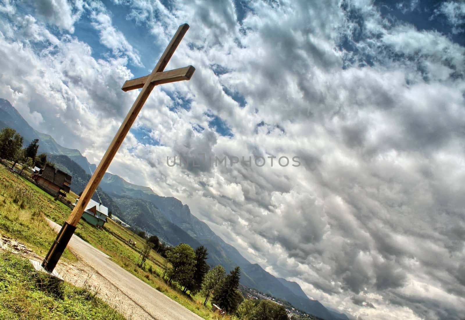 Wooden cross against a blue sky full of clouds