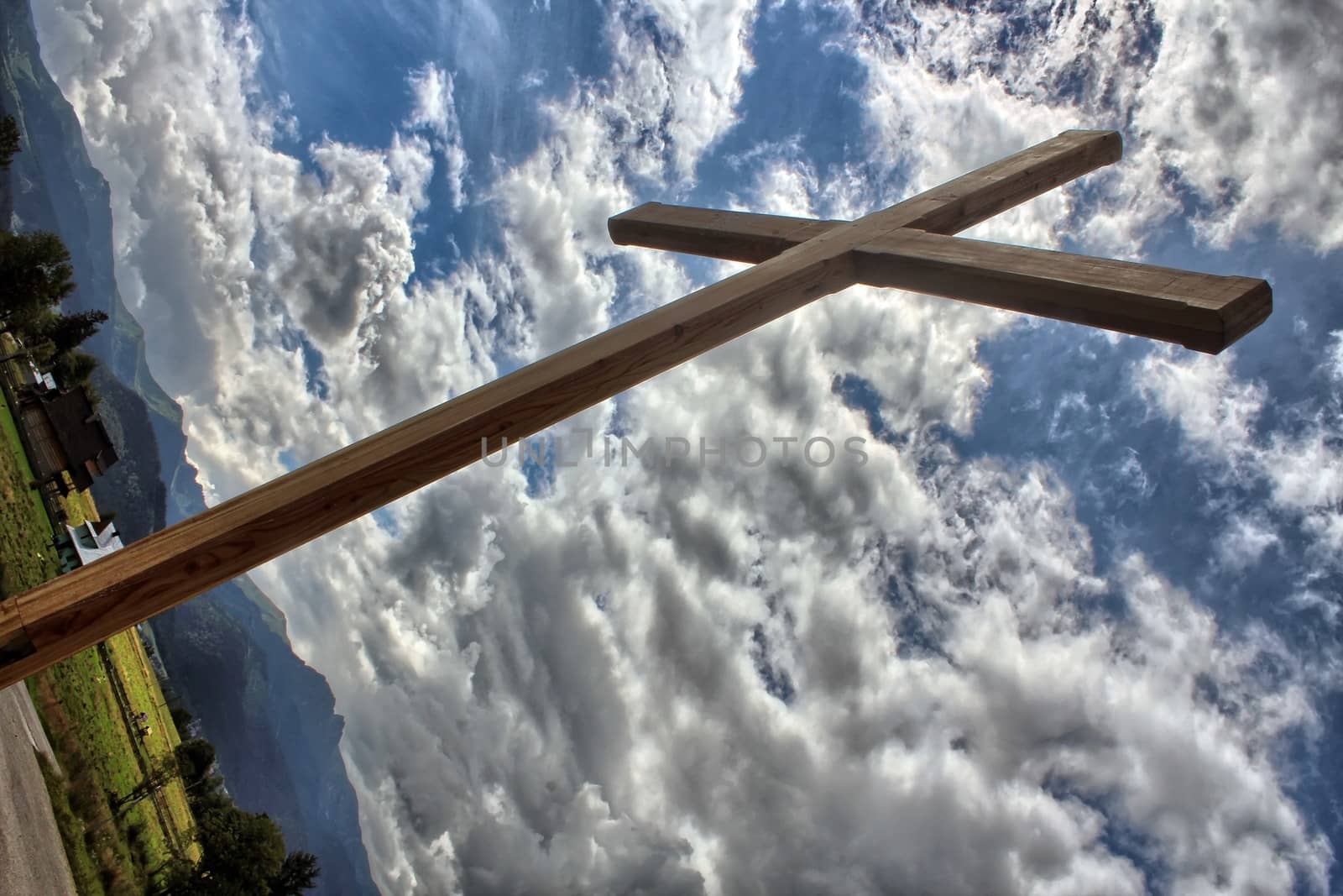 Wooden cross against a blue sky full of clouds