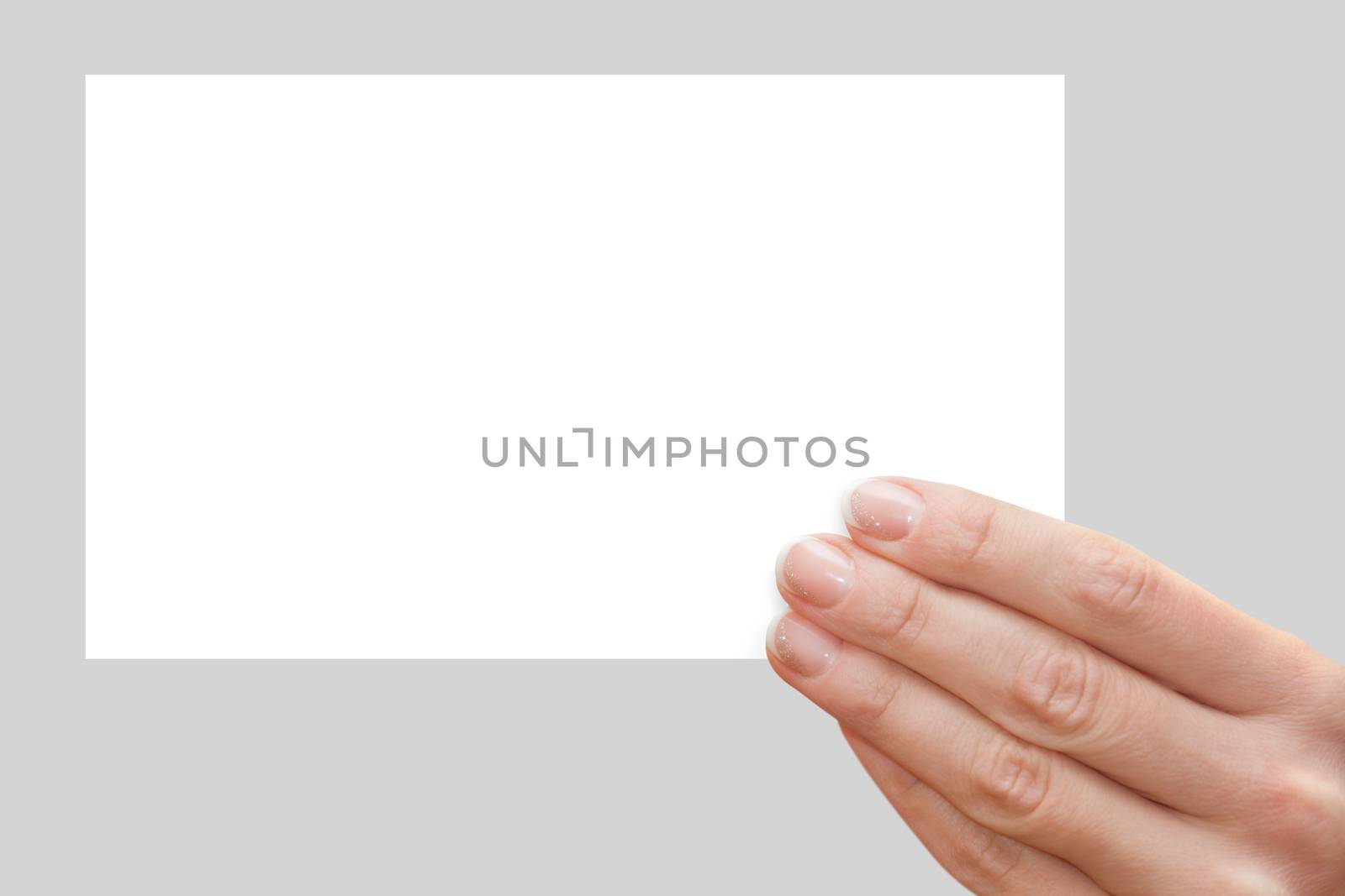 Women's fingers holding a blank white card
