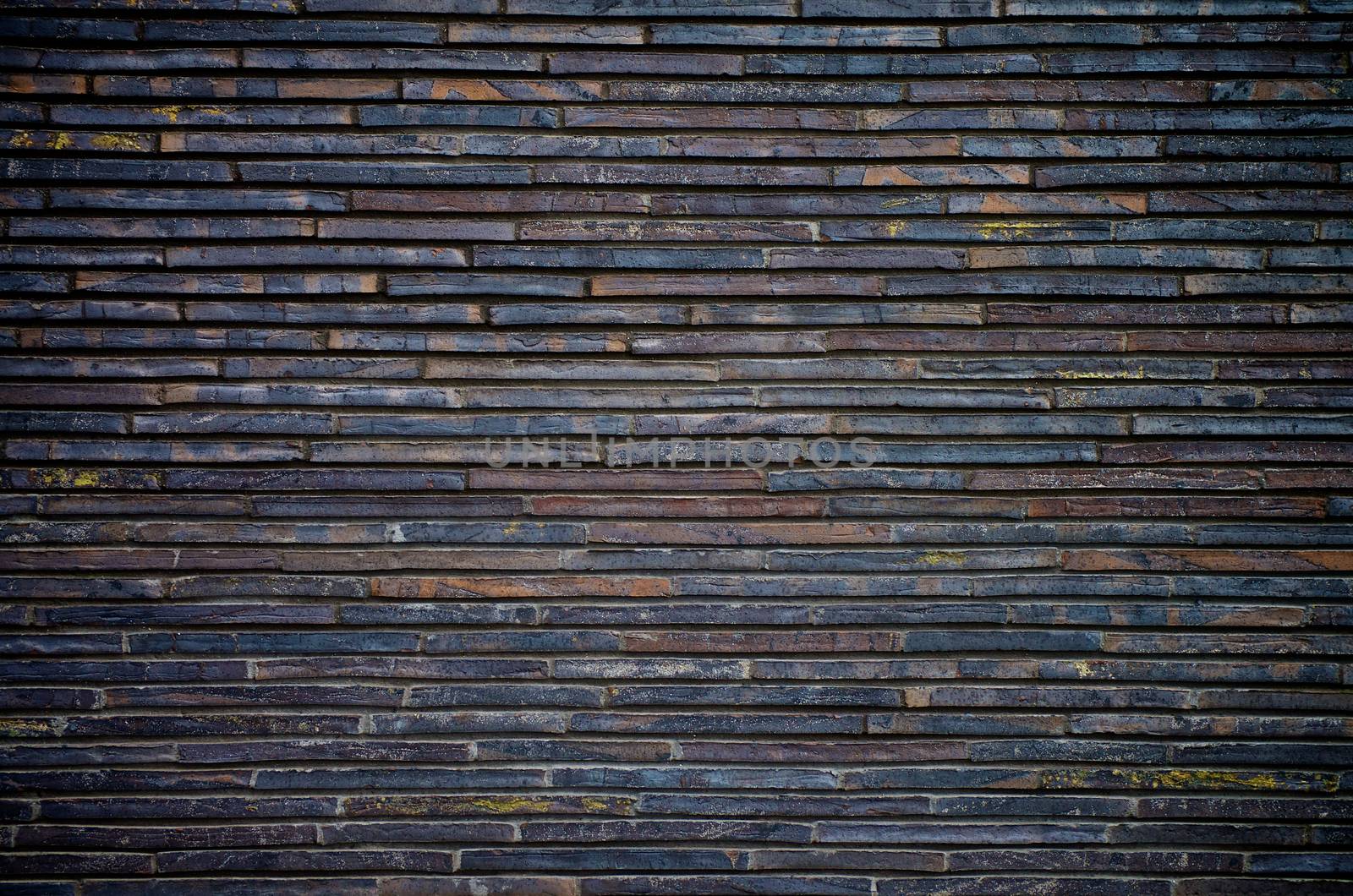 Background of Black, Grey and Brown Plank Stone Exterior Wall closeup