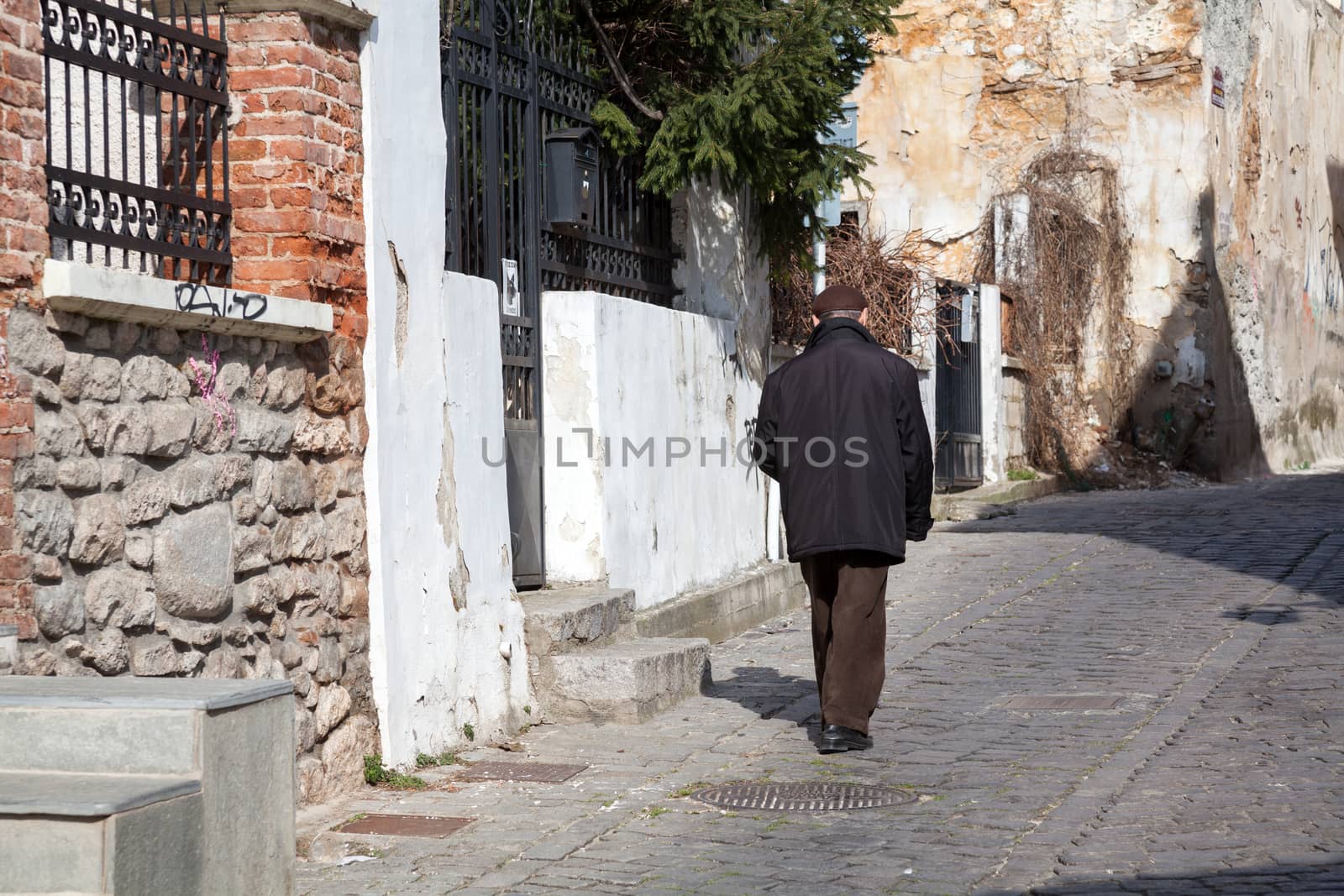 XANTHI, GREECE - FEB 22, 2015: An old man walking in the beautiful old city of Xanthi, Greece