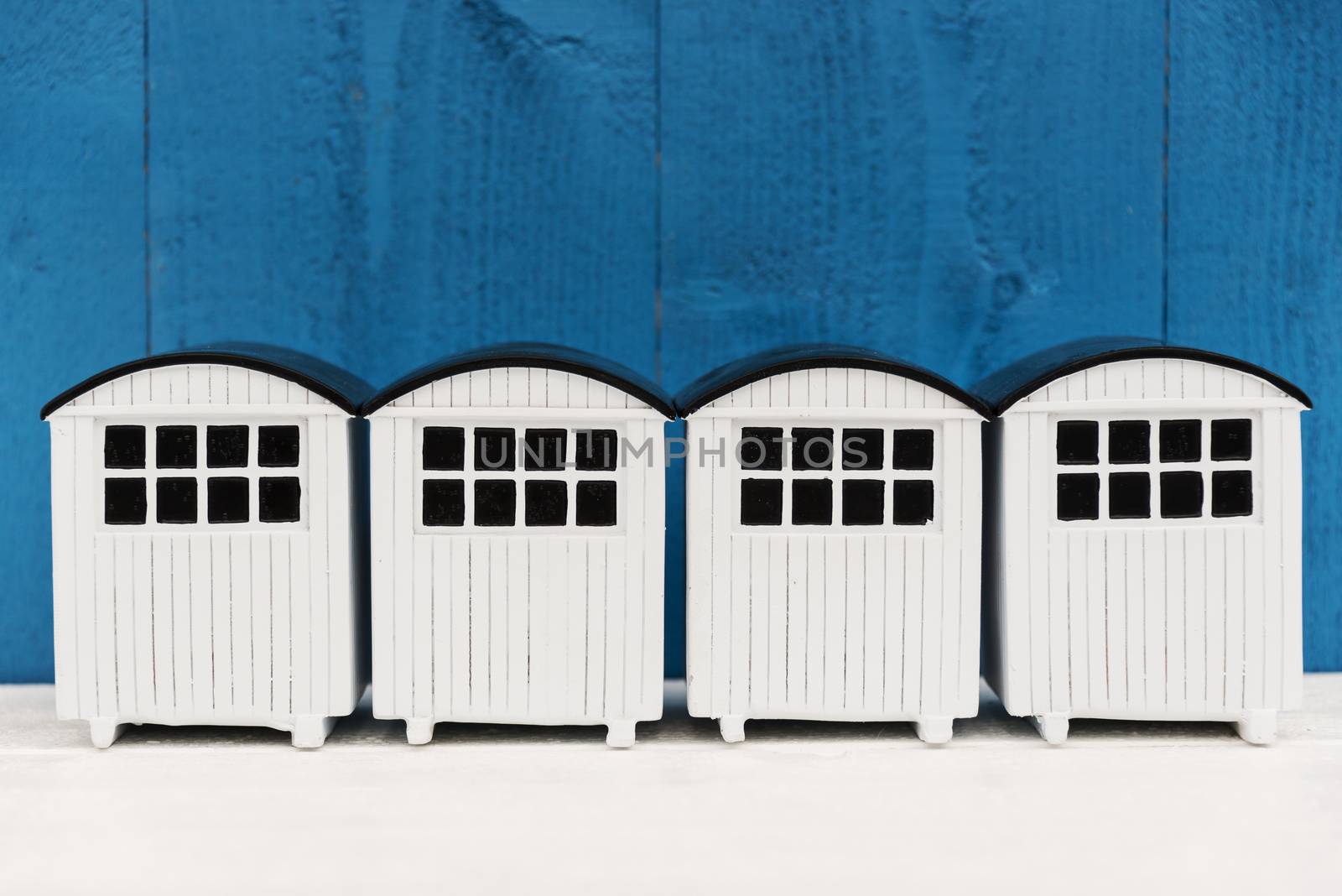 White beach houses in a row against a blue background