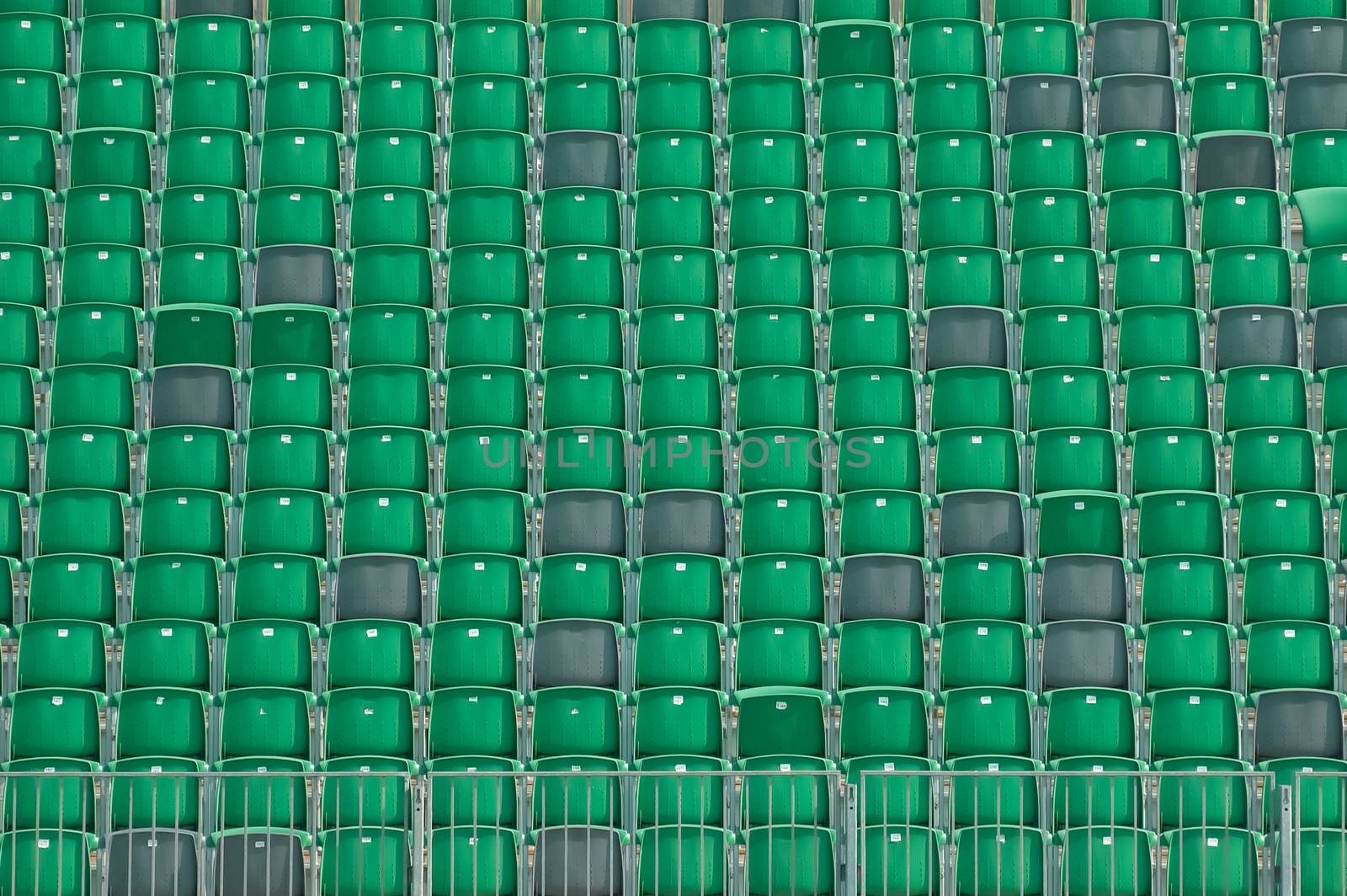 rows of empty plastic grandstand seats in an outdoor sporting venue