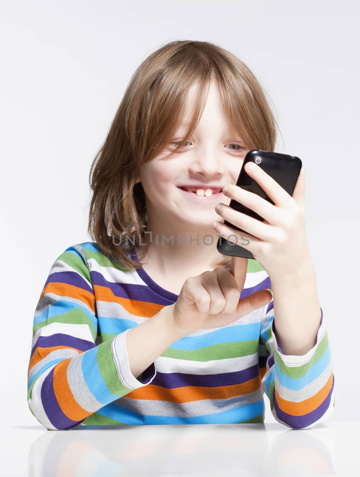 Boy with Blond Hair Reading Text Message on Mobile Phone