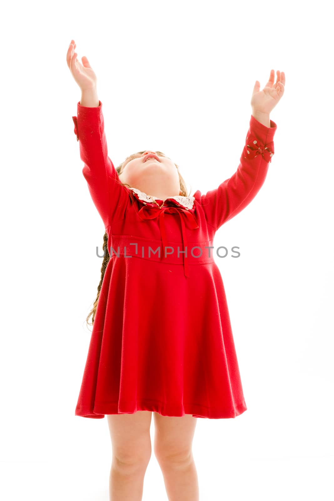Young child with hands up in the air looking up.