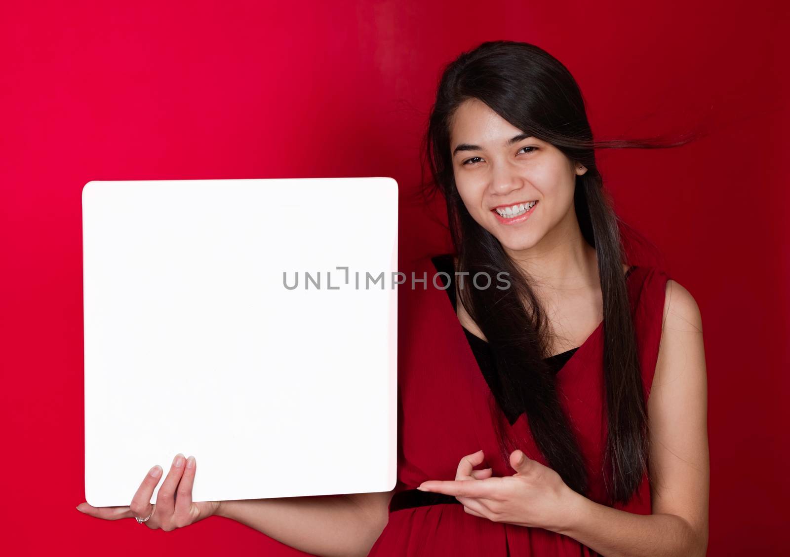 Beautiful biracial teen girl holding up square white sign, point by jarenwicklund