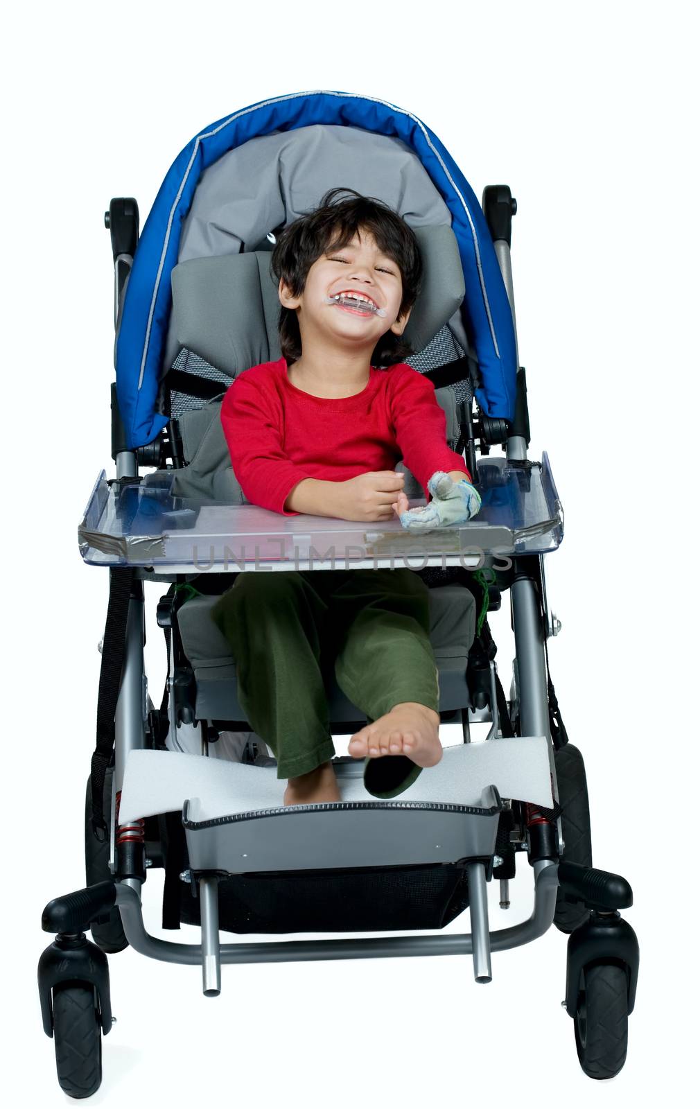 Three year old biracial disabled boy in medical stroller, happy and smiling