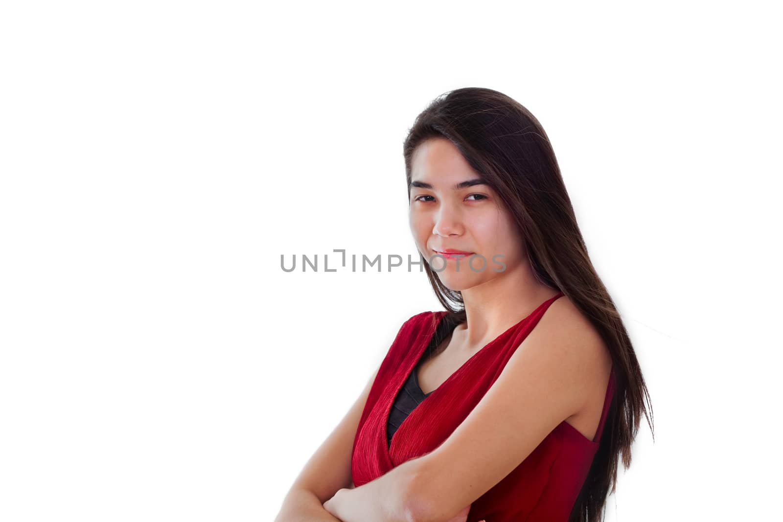 Beautiful biracial teen girl in red dress standing arms crossed, smiling. Challenging expression