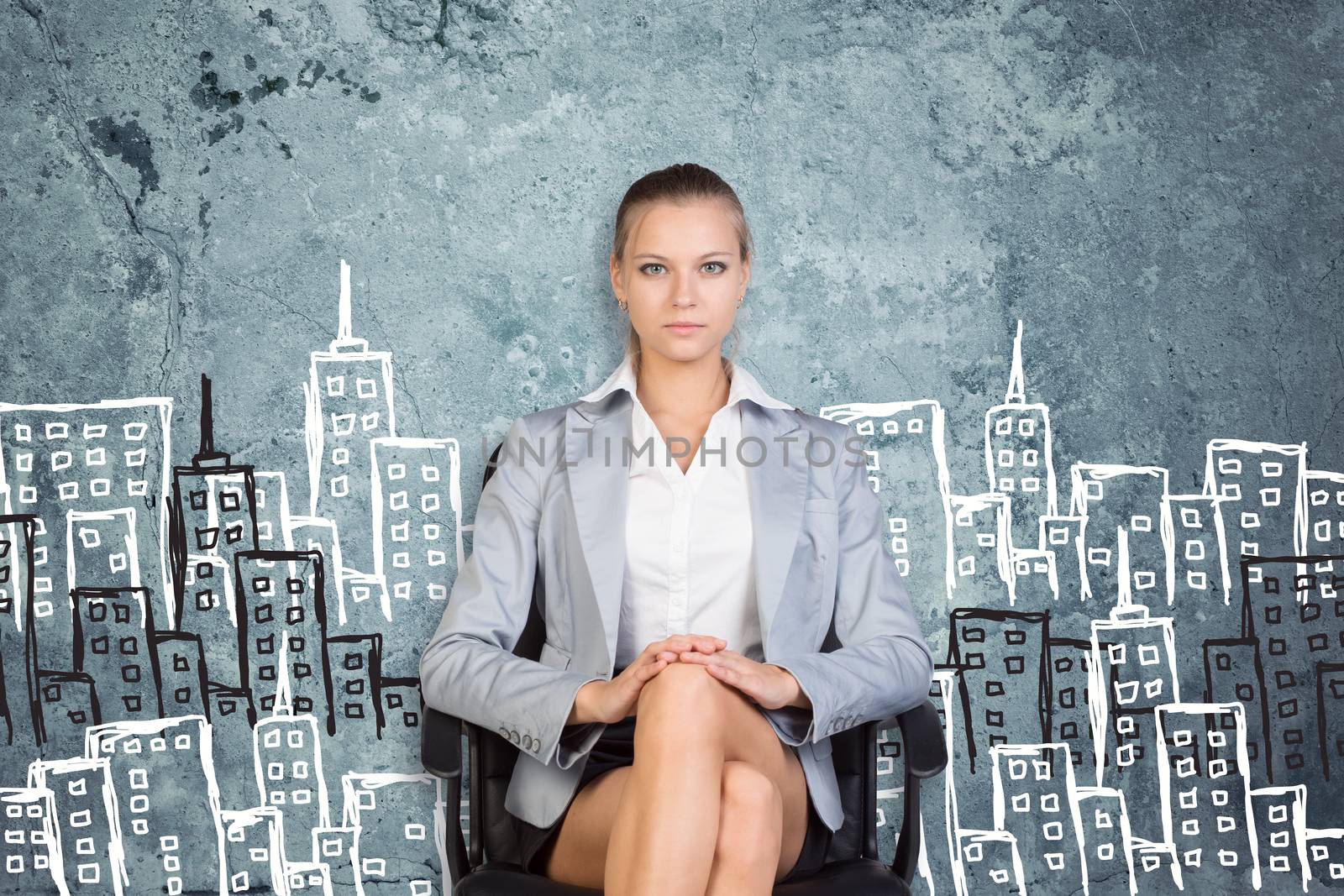 Businesswoman sitting on office chair, looking at camera, against scratched wall with sketch of city