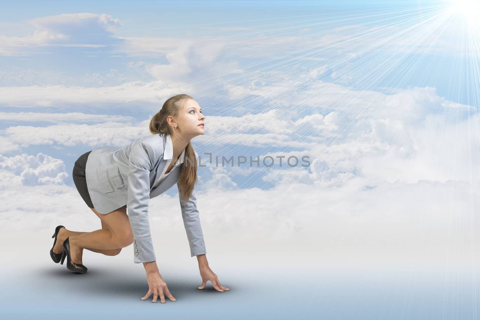 Businesswoman standing in running start pose, looking at light shining ahead. Sky and clouds as backdrop