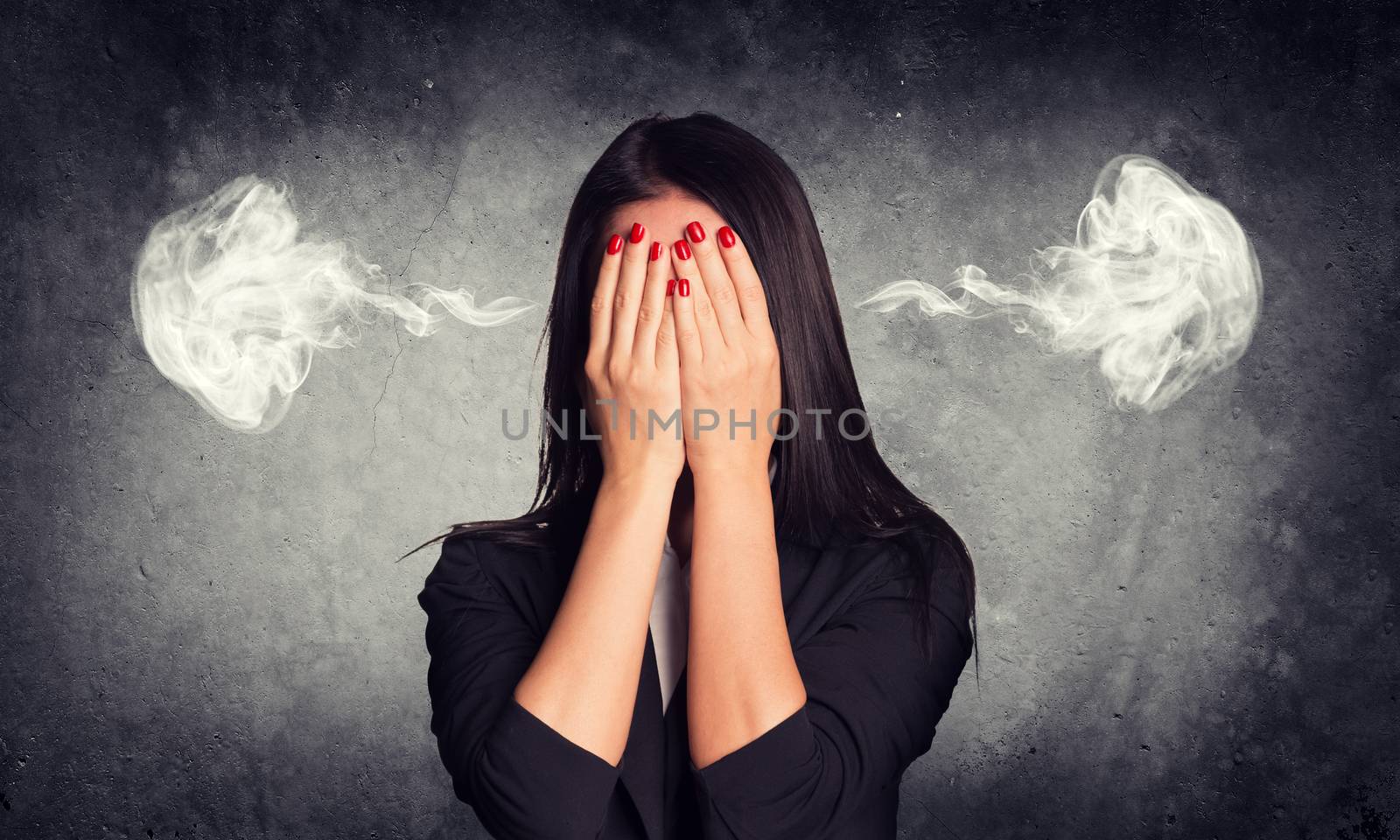 Close-up portrait of businesswoman hiding face in her hands, with smoke from ears by cherezoff