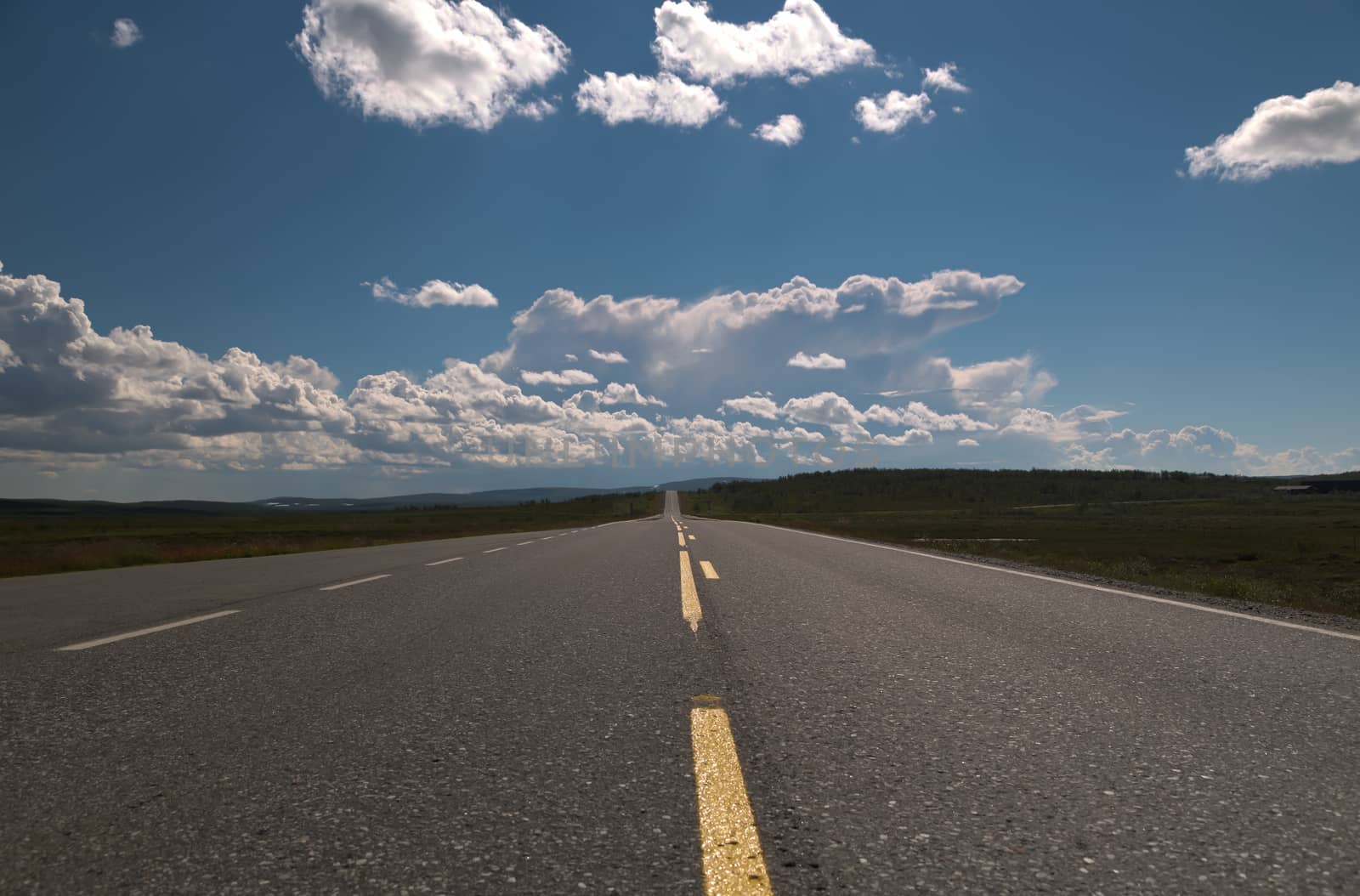 Picture of a empty long road with blue sky