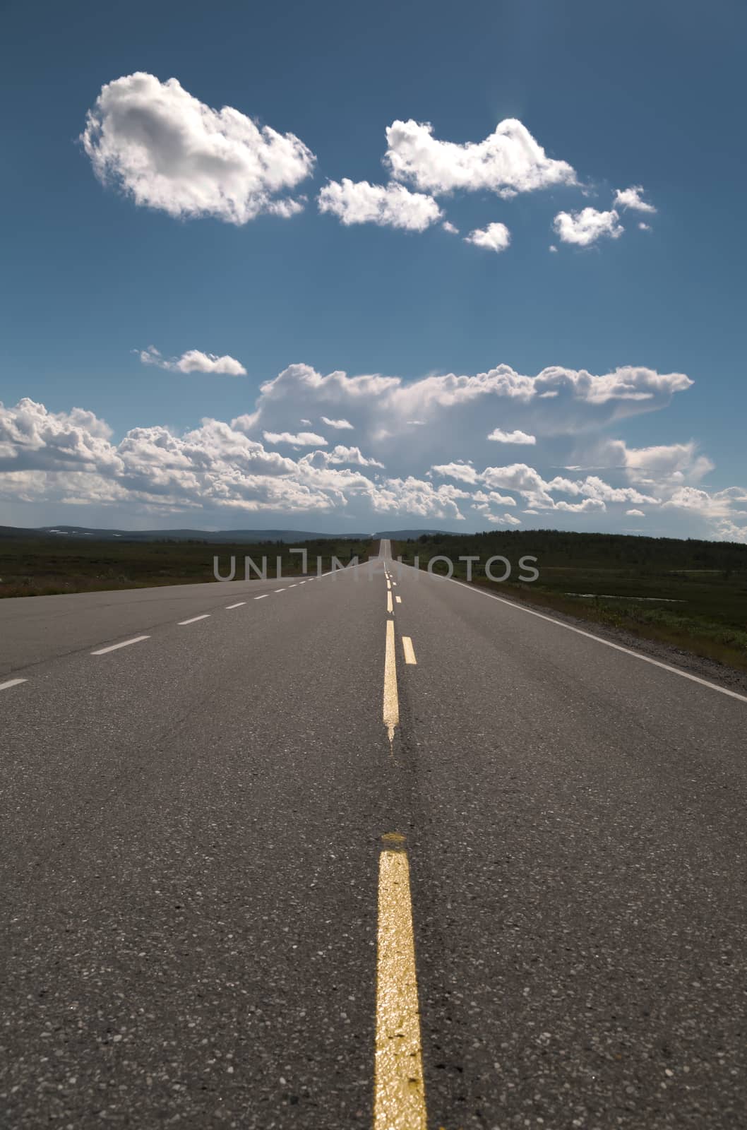 Picture of a empty long road with blue sky