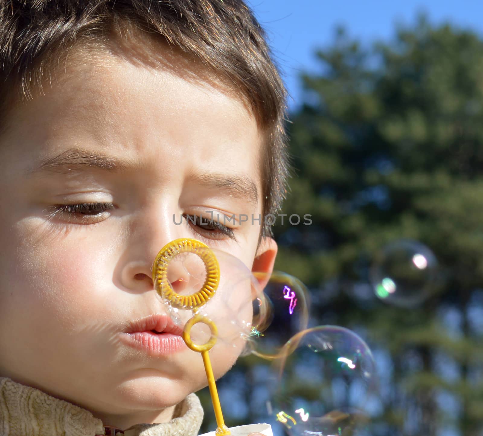 Cute boy makes soap bubbles