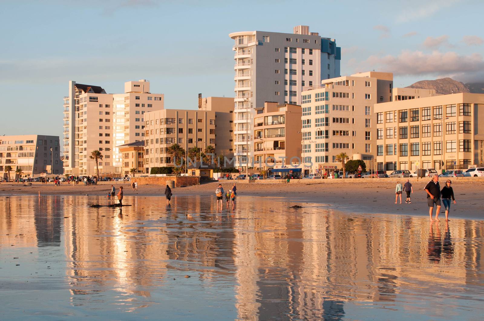 CAPE TOWN, SOUTH AFRICA - DECEMBER 20TH, 2014: Unidentified people on the beach at sunset in The Strand near Cape Town. It is a favorite tourists area

