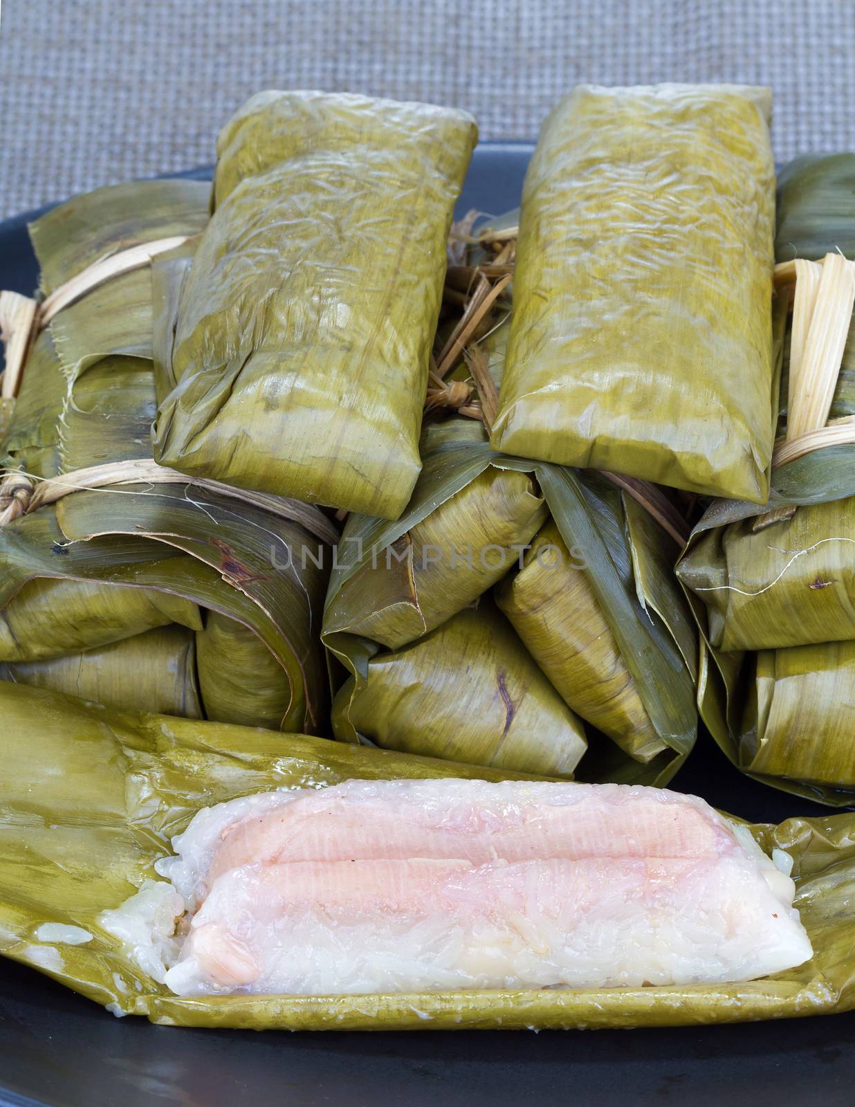 Glutinous rice with banana and peanut steamed in banana leaf - Thai traditional food