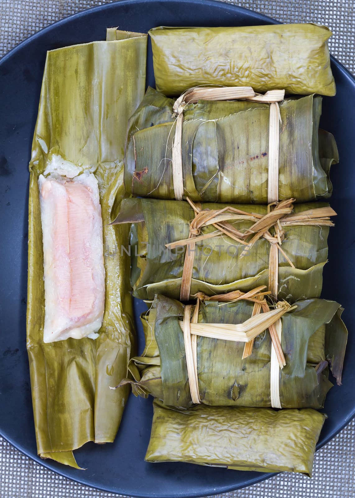 Glutinous rice with banana and peanut steamed in banana leaf - Thai traditional food