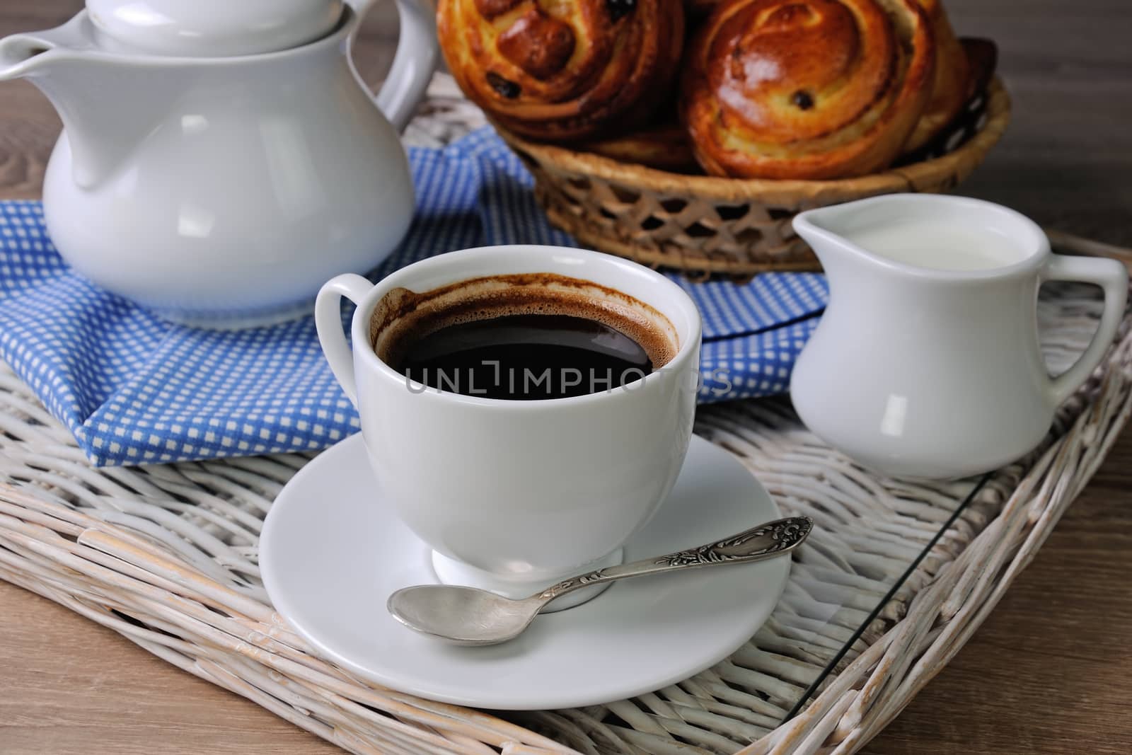 Cup of coffee with a bun, milk on a tray