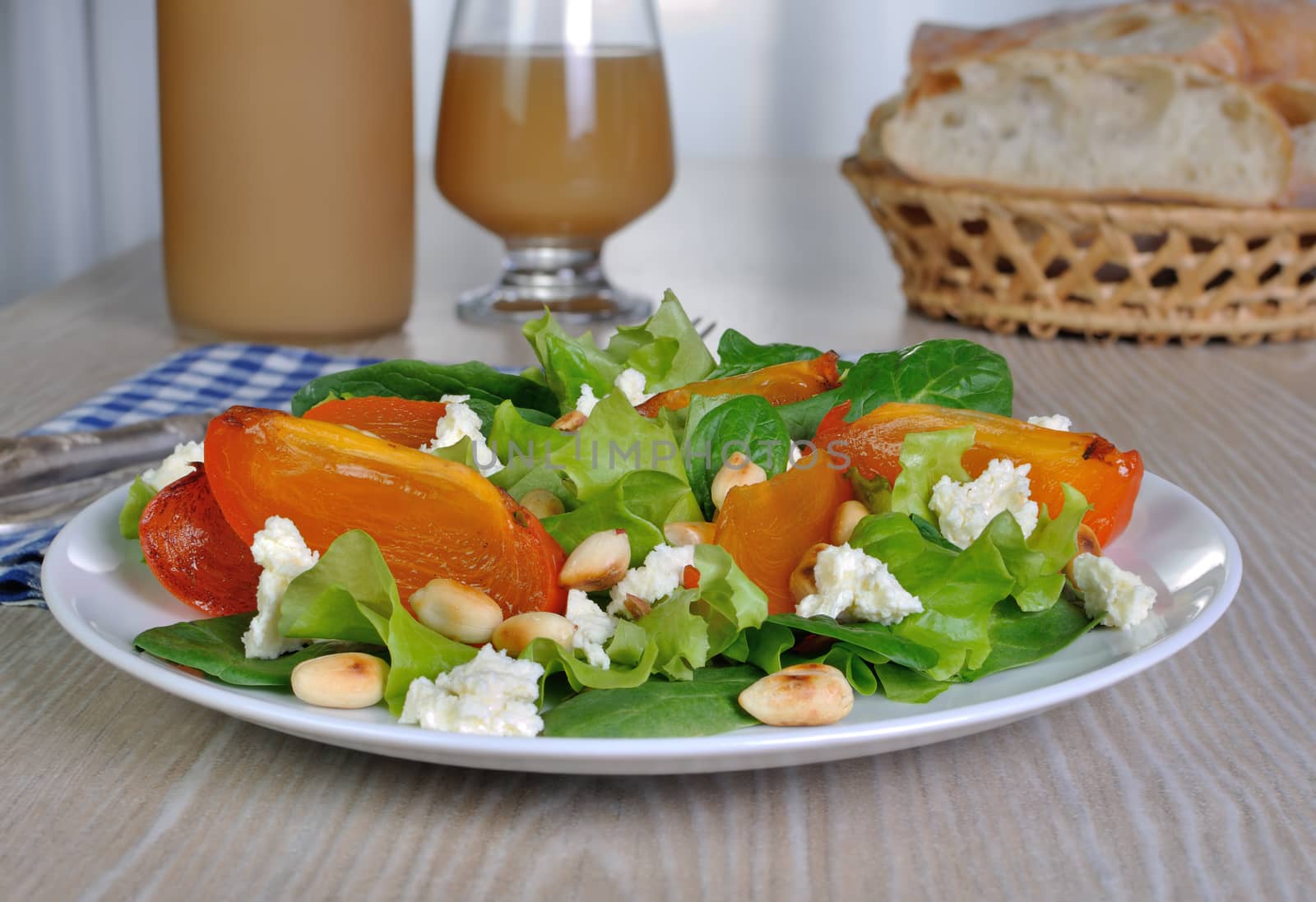 Fresh salad mix with persimmons, feta cheese and peanuts