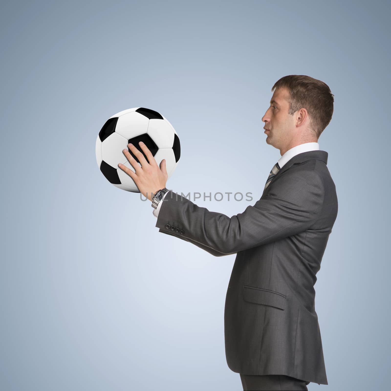 Businessman in suit hold soccer ball. Blue background