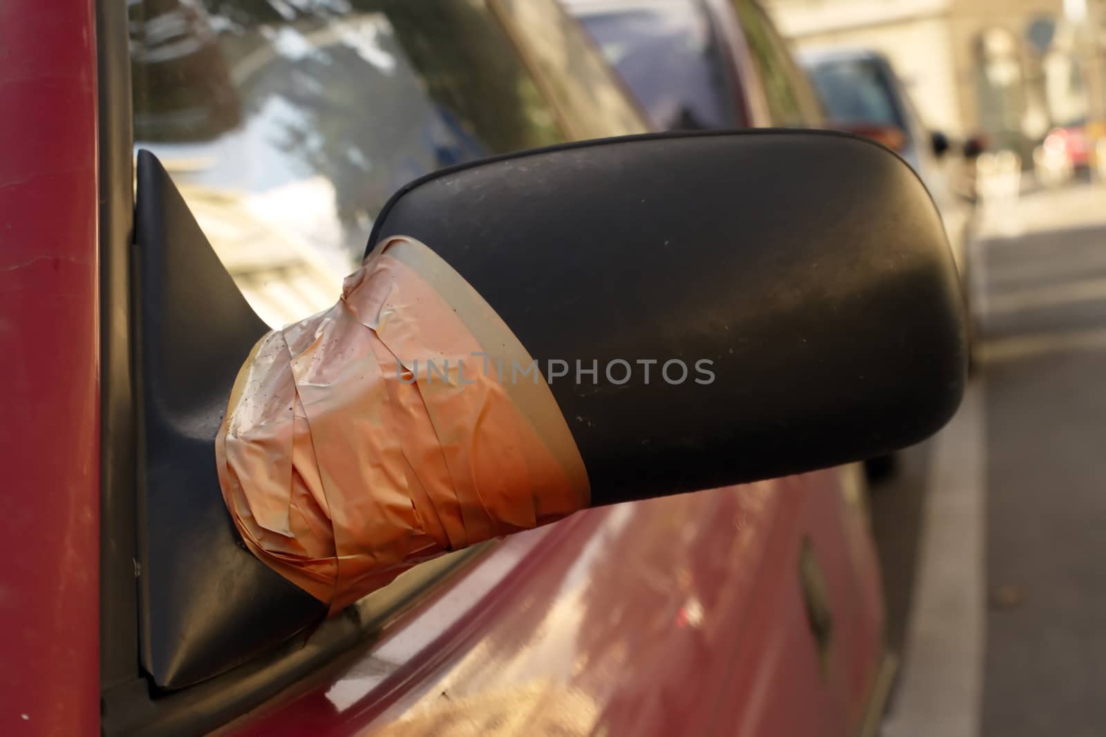 Close up of damaged rearview mirror repaired with scotch