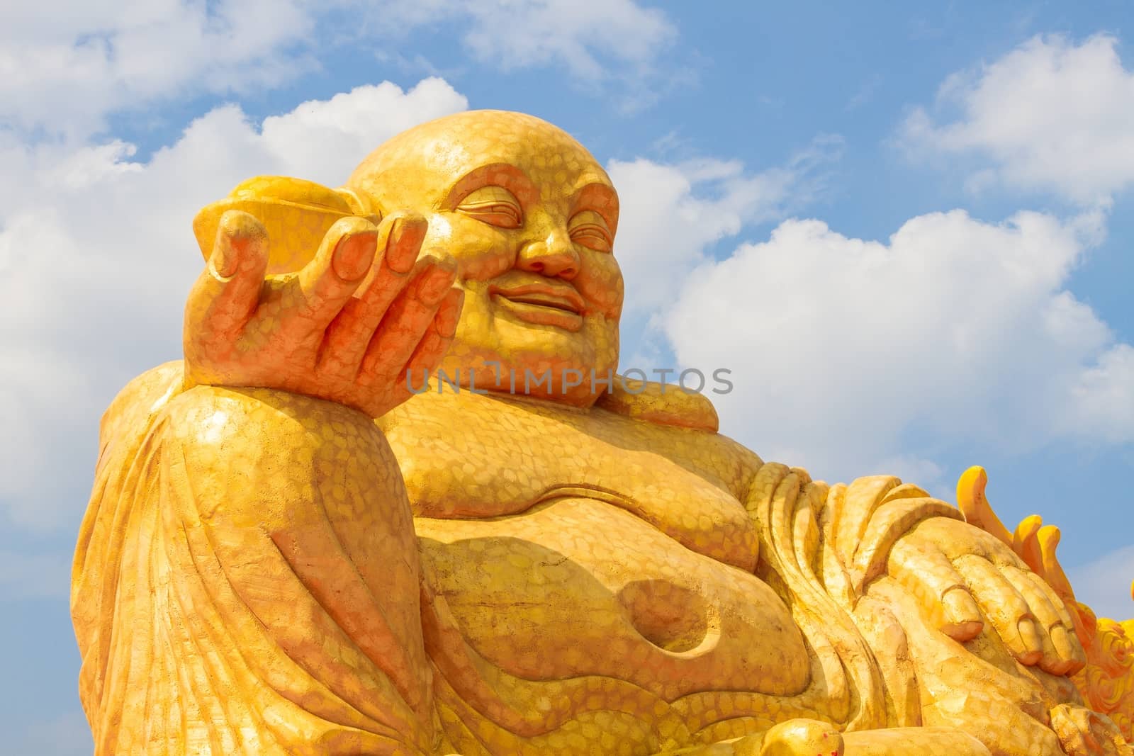 Budai or Hotei - god of riches, Fat Buddha with money in his hand, in background of blue sky