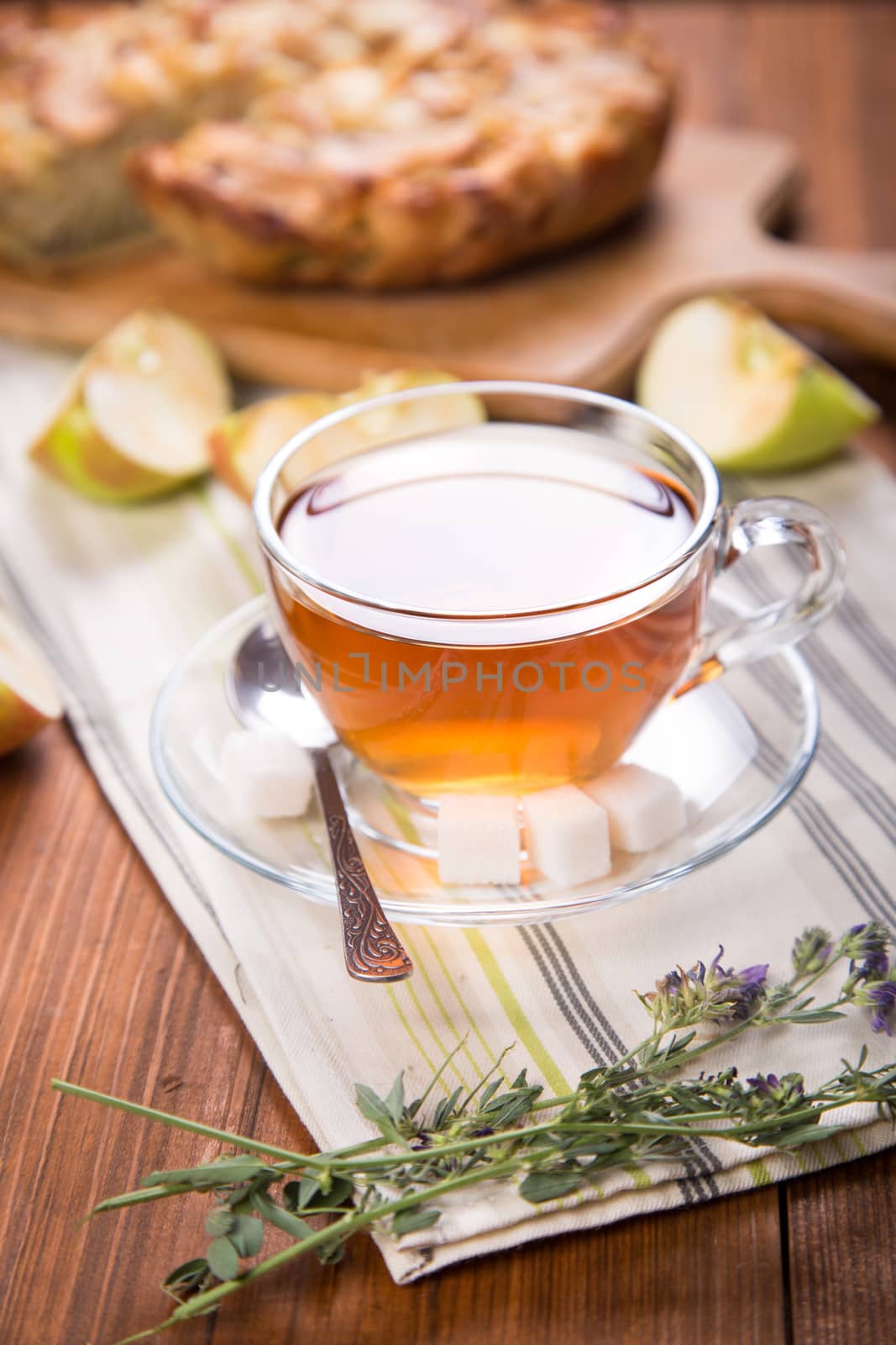  cup of tea,apple pie, with an cut piece on wooden background